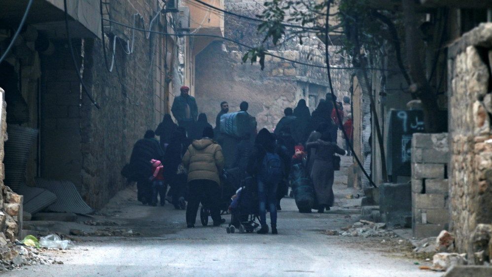 People carry belongings as they flee deeper into the remaining rebel-held areas of Aleppo