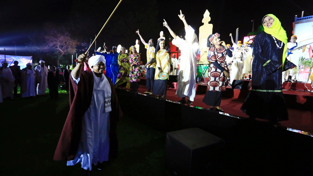Bashir waves to traditional performers in Khartoum