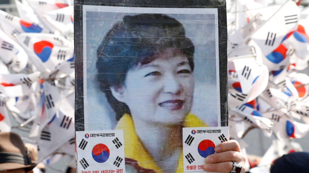A supporter of South Korea''s ousted leader Park Geun-hye holds up Park''s portrait during a rally in front of a prosecutor''s office in Seoul