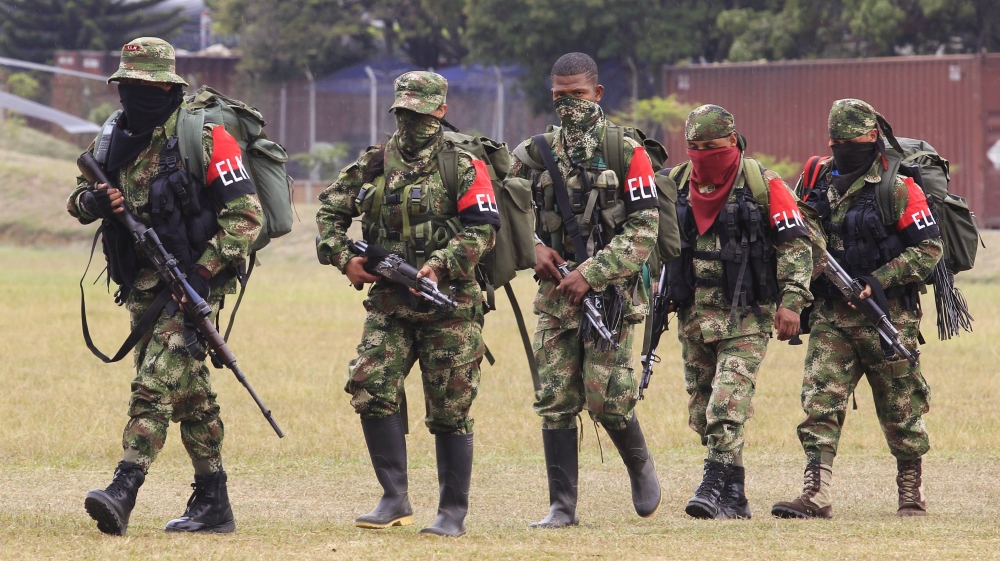 Defected members of Colombian guerrilla group ELN walk to a military base to surrender and handover their weapons, in Cali