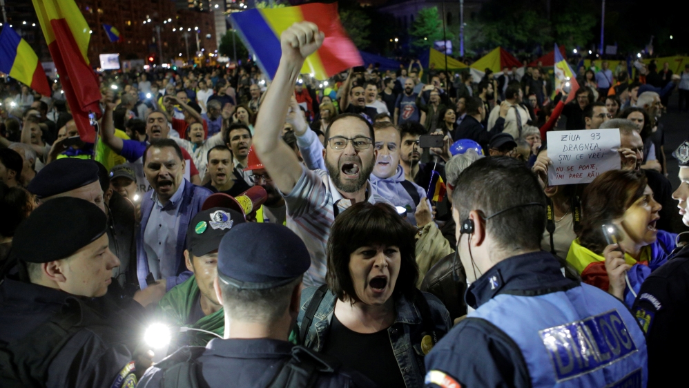 Protesters shout slogans during a demonstration in front of the government building in Bucharest,