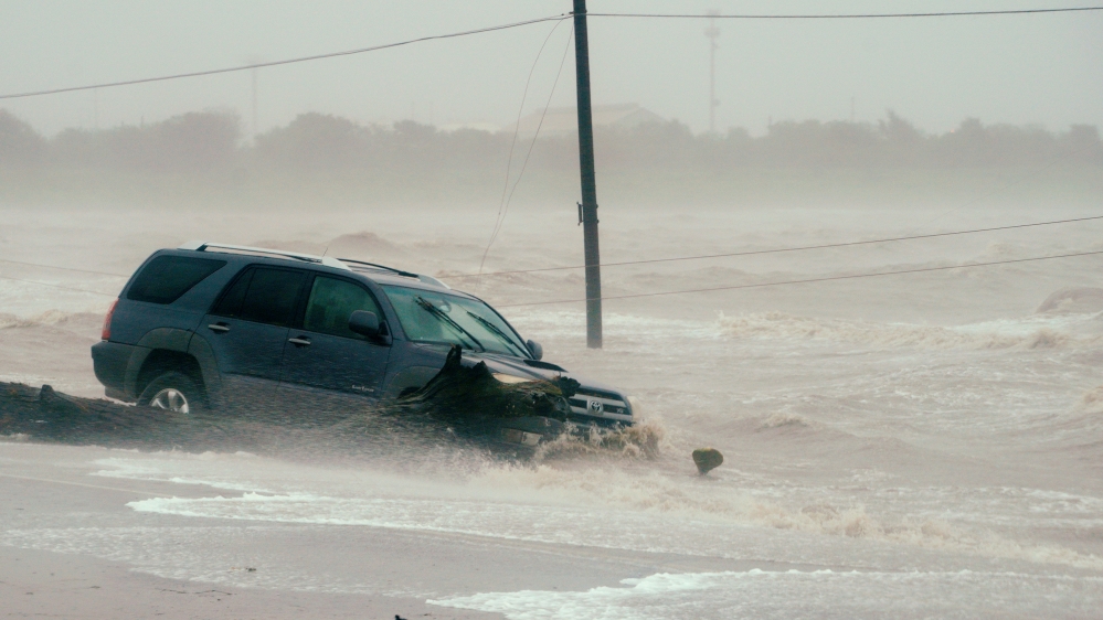 A car is surrounded by floodwaters from Hurricane Harvey in Point Comfort