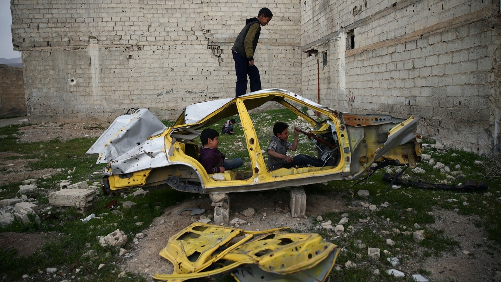 Boys play on a wrecked car in the rebel held besieged Douma neighbourhood of Damascus, Syria April 1, 2017. Picture taken April 1, 2017. REUTERS/Bassam Khabieh TPX IMAGES OF THE DAY