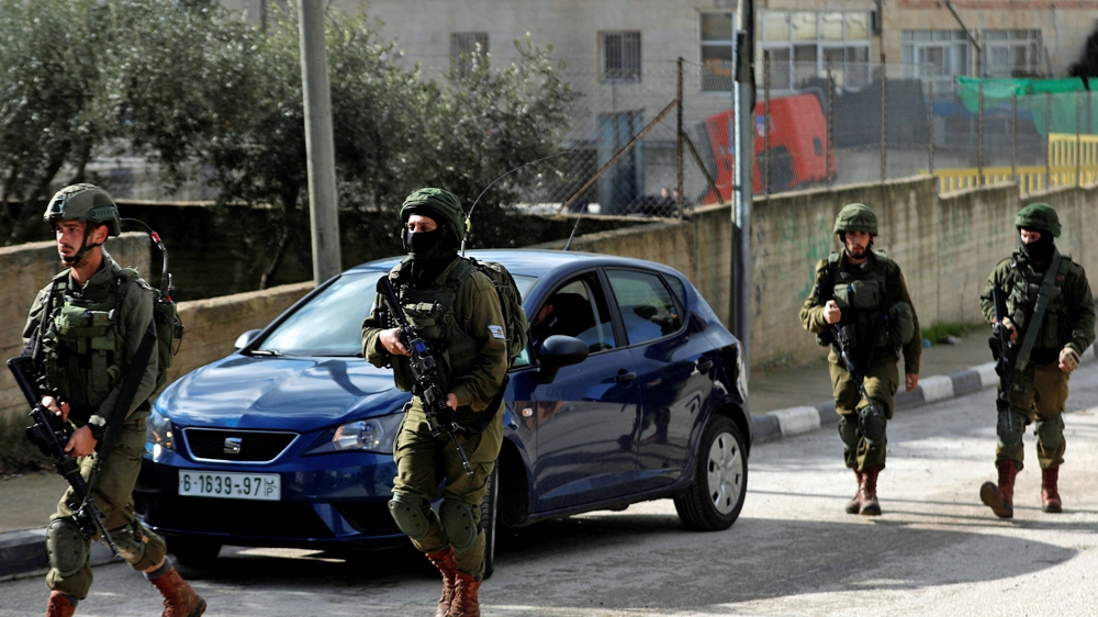 Israeli forces walk during a raid in Ramallah