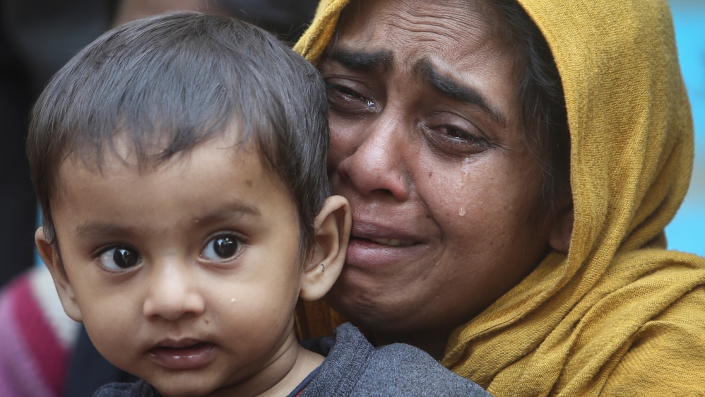 A Rohingya Muslim woman cries as she holds her daughter after they were detained by Border Security Force (BSF) soldiers while crossing the India-Bangladesh border from Bangladesh, at Raimura village