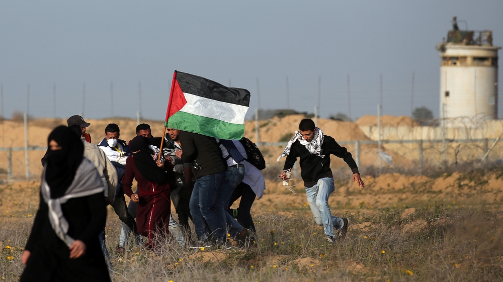 Medics and demonstrators evacuate a wounded Palestinian during a protest at the Israel-Gaza border fence, in the southern Gaza Strip