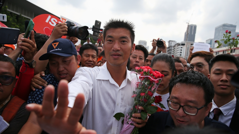 Thanathorn Juangroongruangkit, leader of the Future Forward Party, greets his supporters as he arrives at a police station to hear a sedition complaint filed by the army in Bangkok