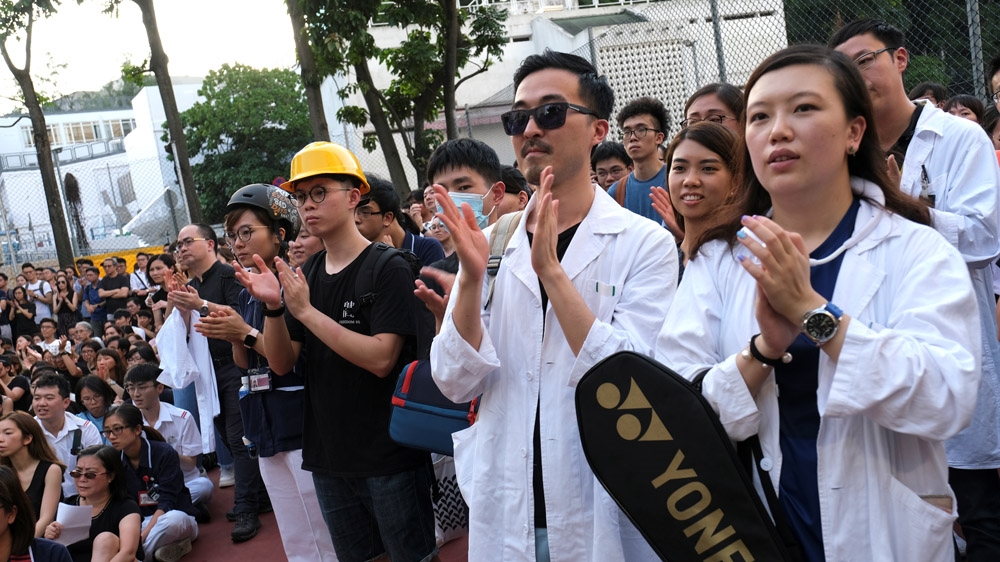 Public hospital doctors, nurses and employees wearing helmets as they attend a rally against Sunday’s Yuen Long
