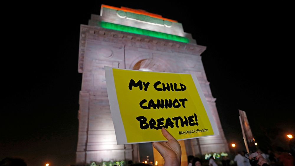A protester holds a placard that reads " my child cannot breathe" in Delhi