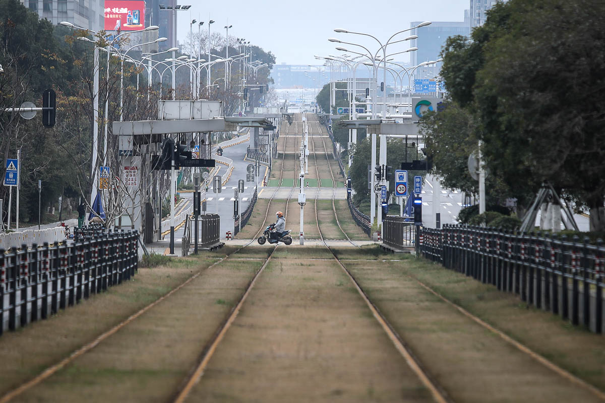 WUHAN, CHINA - FEBRUARY 07: A resident rides a motorbike across an empty track on February 7, 2020 in Wuhan, Hubei province, China. The number of those who have died from the Wuhan coronavirus, known