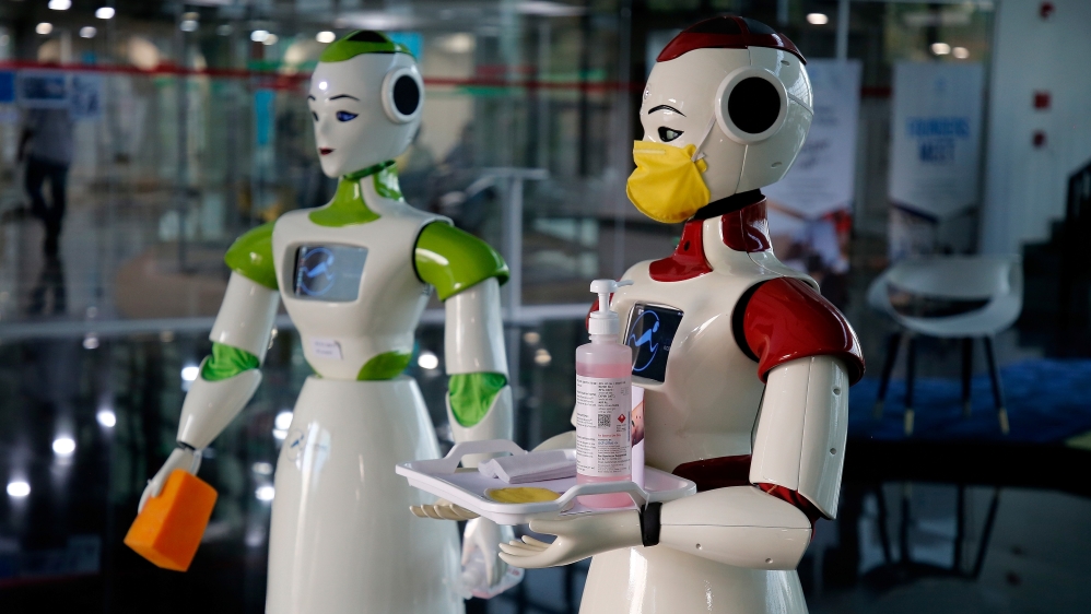 A robot, developed by a start-up firm Asimov Robotics, holds a tray with face masks and sanitizer after the two robots were launched to spread awareness about the coronavirus, in Kochi