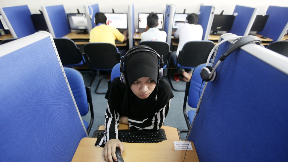 A woman browses the Internet at a cyber cafe in Putrajaya