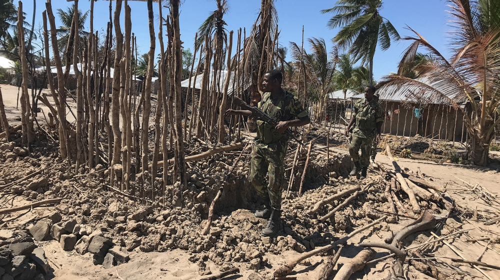 Mozambican Army soldiers bring down a structure torched by attackers to be rebuilt as shelter for people fleeing the recent attacks, in Naunde, northern Mozambique, on June 13, 2018. Until last week,