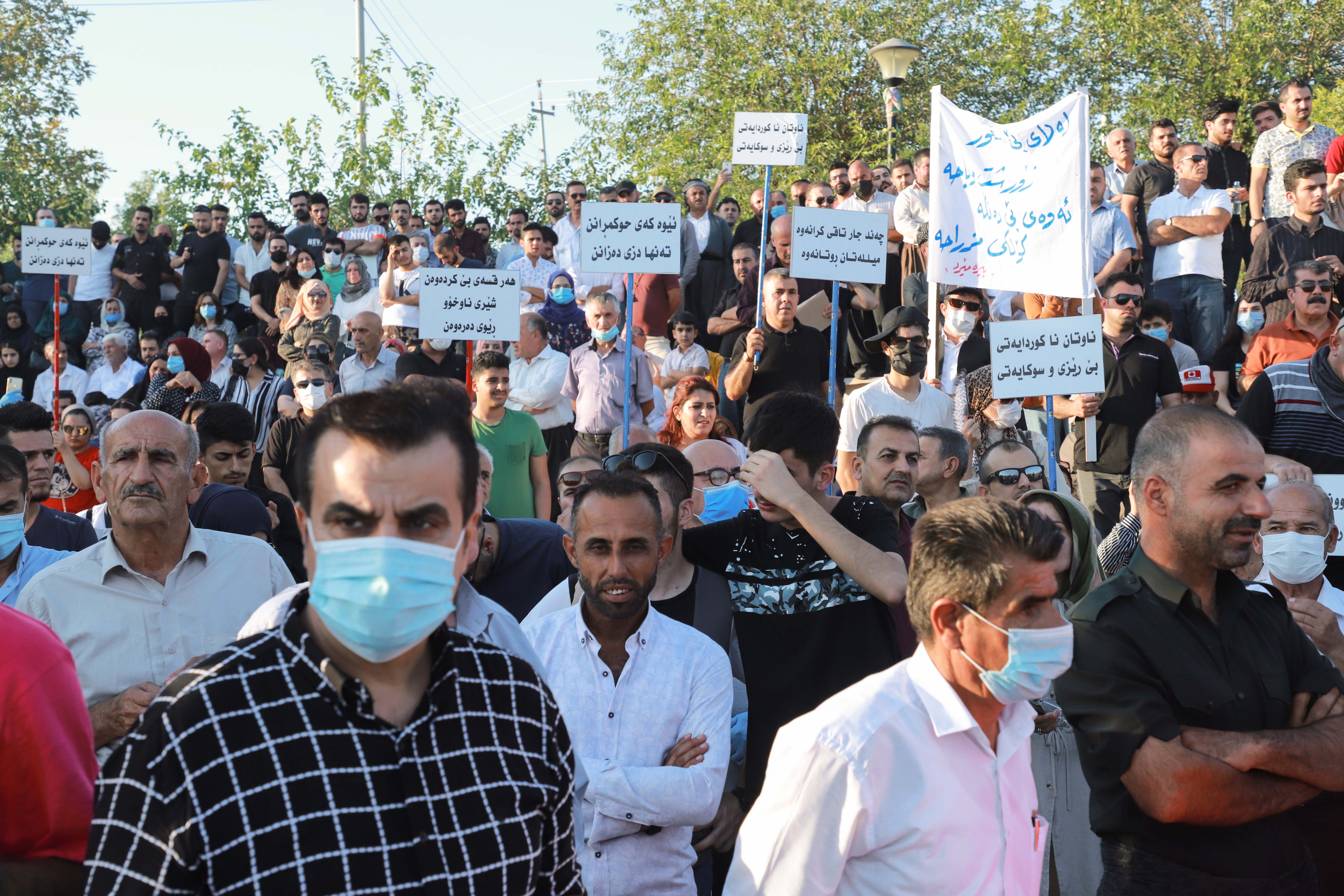 Iraqi Kurds lift placards during a demonstration at the the Freedom Park in the center of Sulaimaniyah in Iraq&#39;s autonomous Kurdish region, on August 12, 2020 [File: Shwan Mohammed/AFP]