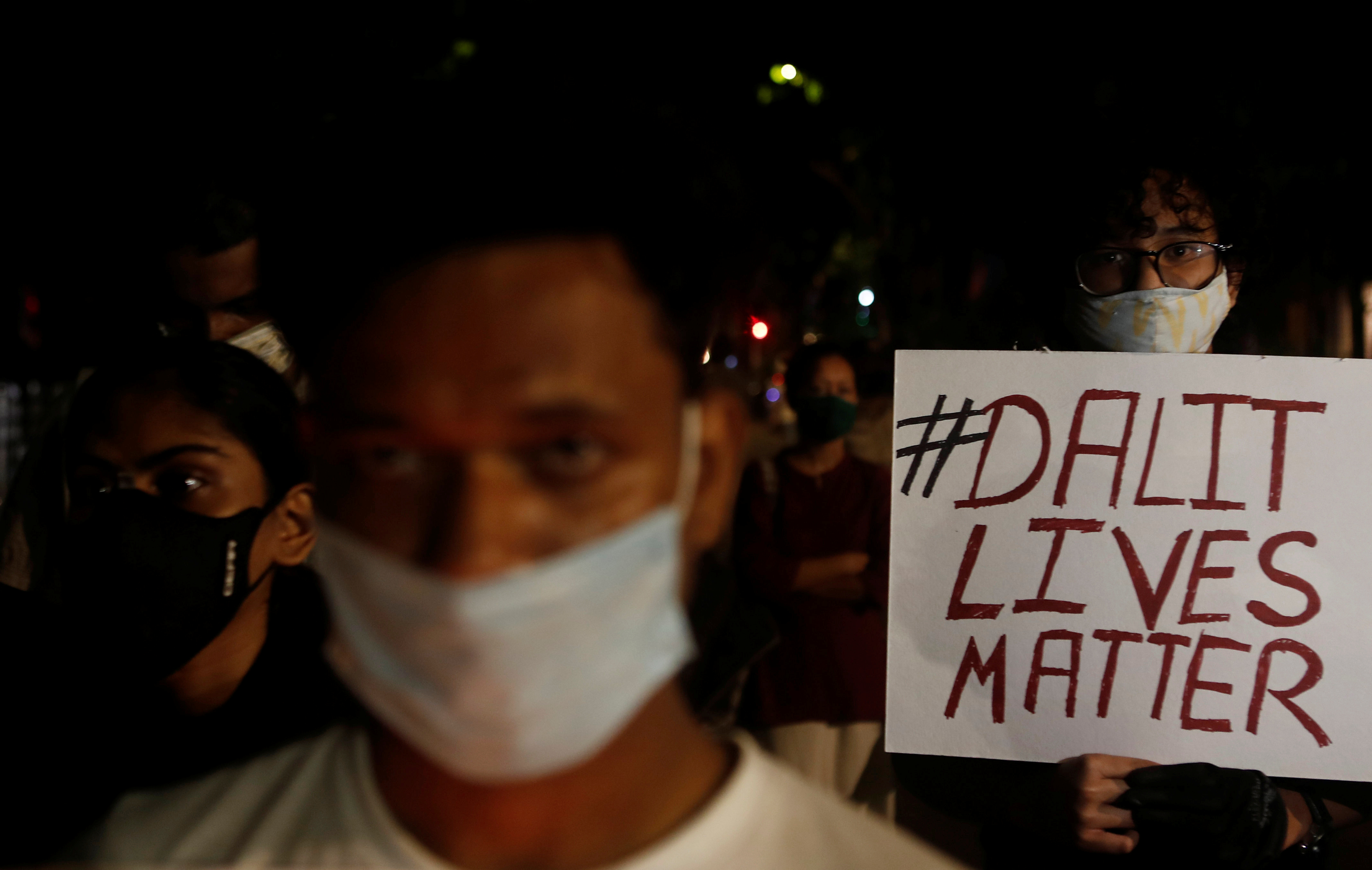 A man holds a placard during a protest over the death of a Hathras rape victim in Mumbai [Francis Mascarenhas/Reuters]