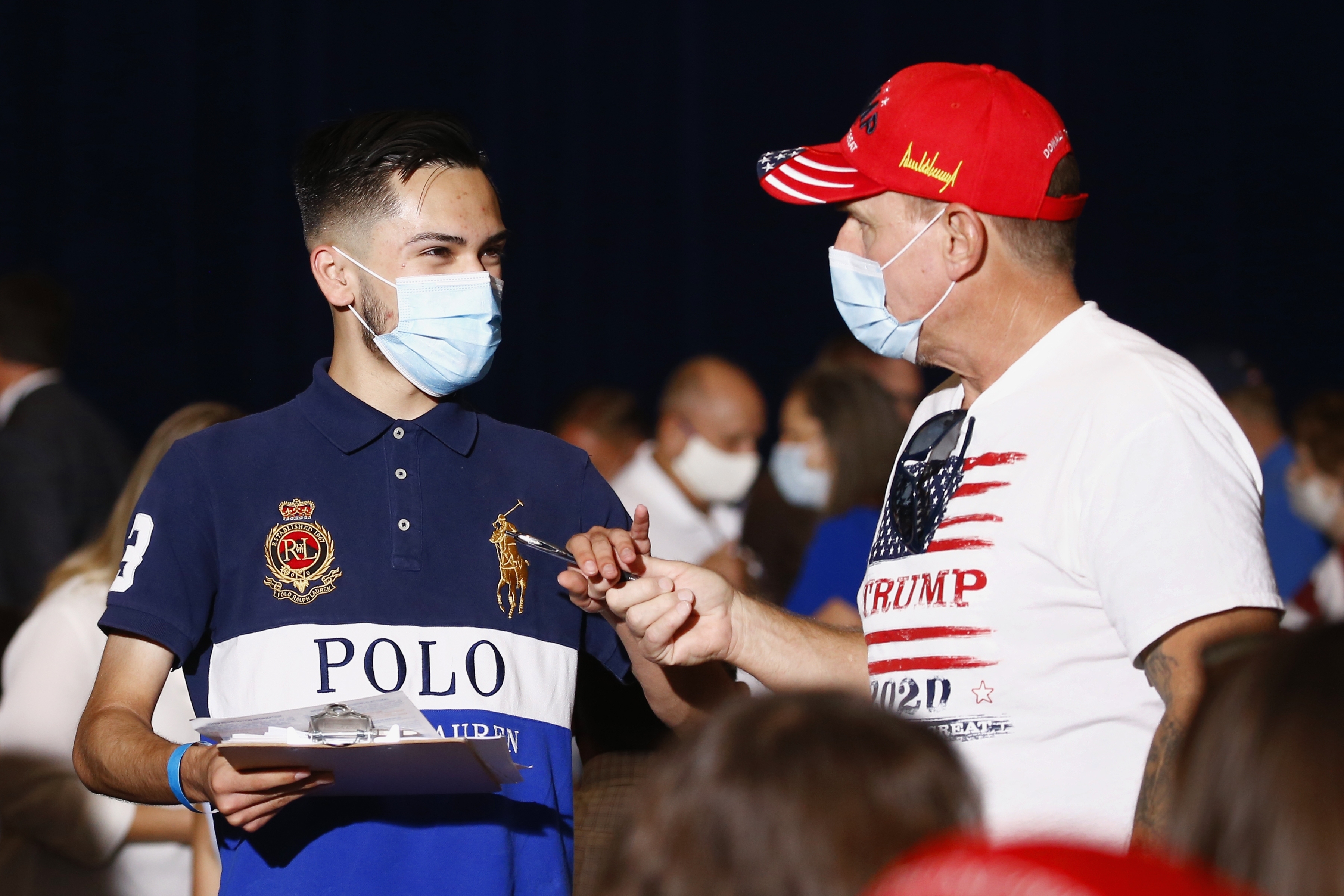 Volunteers canvass the crowd to get people to register to vote prior to an event with Vice President Mike Pence [File: Ross D. Franklin/AP]