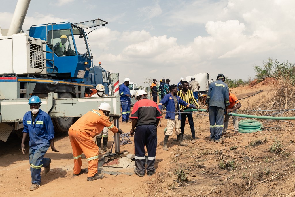 Rescue workers install a water pump to drain water from a mine shaft [Jekesai Njikizana/AFP]