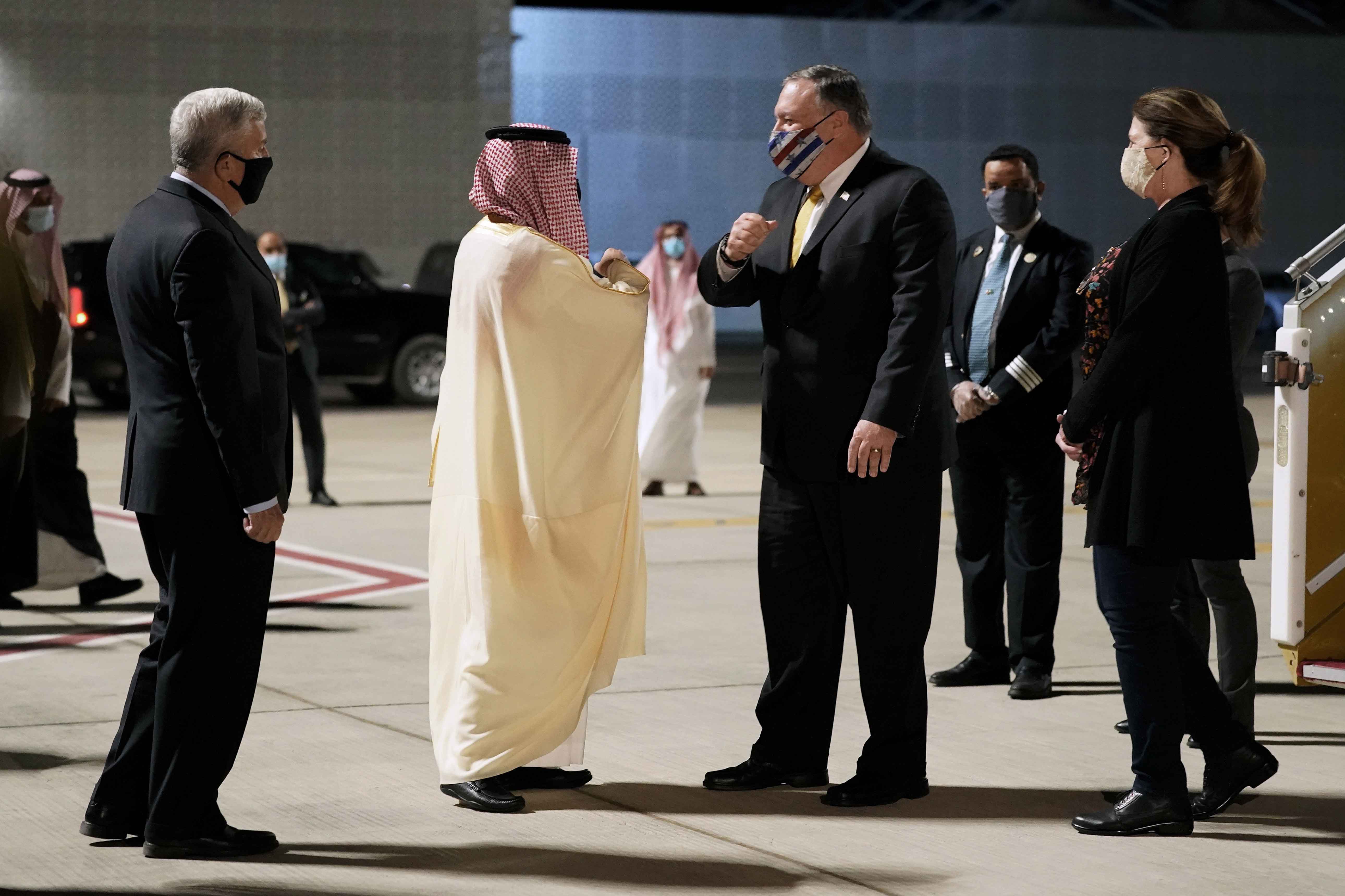 US Ambassador to Saudi Arabia John Abizaid and Saudi Arabia&#39;s Foreign Minister Faisal bin Farhan greet Secretary of State Mike Pompeo and his wife Susan as they arrive at Neom Bay Airport in Neom, Saudi Arabia on November 22, 2020 [AP/Patrick Semansky]