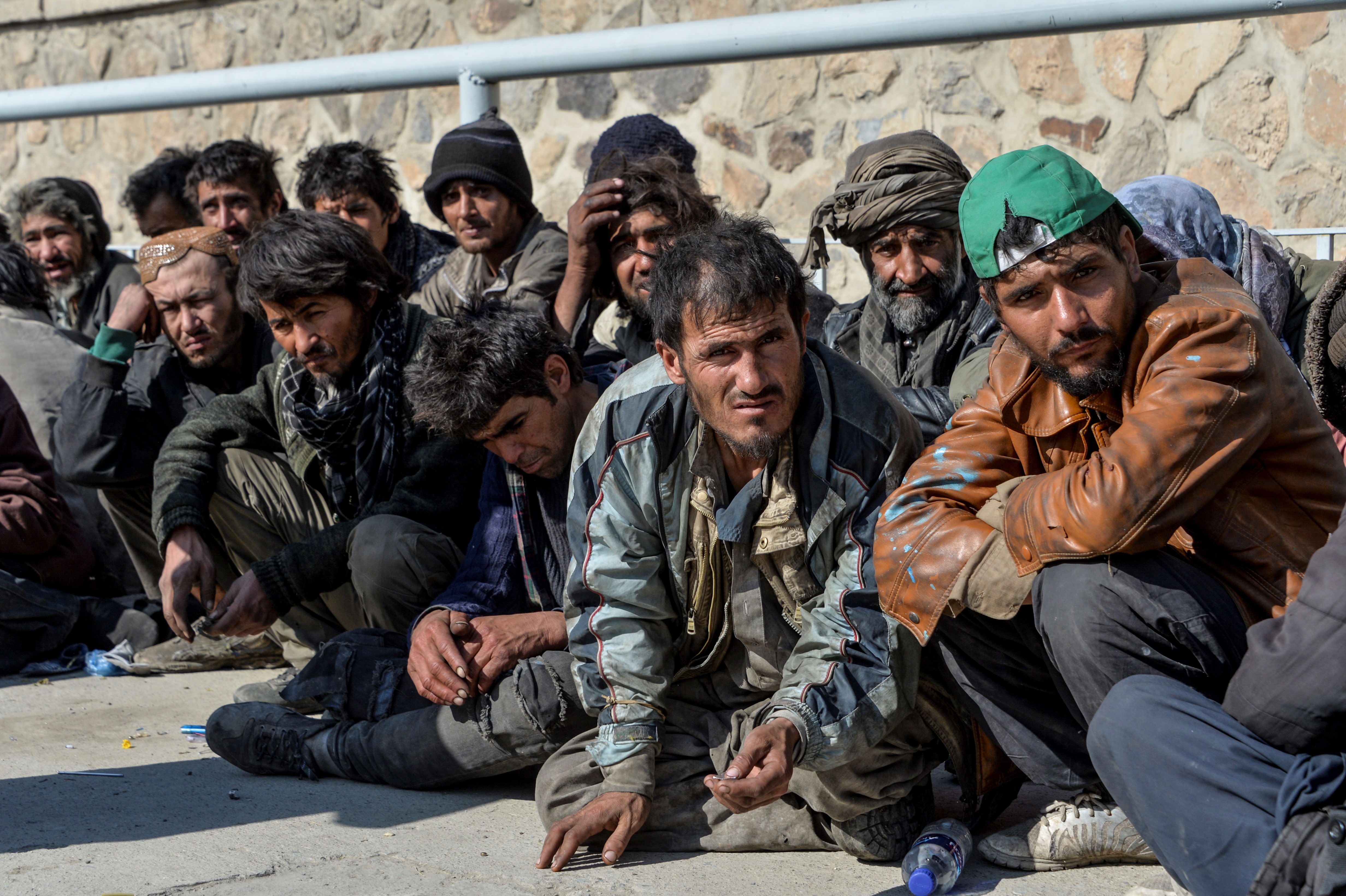 In this photograph taken on November 13, 2019, drug addicts look on as they wait for registration after arriving at a drug treatment centre in Kabul, as part of a compulsory detox programme launched by the government. - At a sprawling rehabilitation centre on the outskirts of Kabul, dozens of dazed-looking drug addicts clamber out of police buses and shuffle toward the facility. (Photo by NOORULLAH SHIRZADA / AFP) / To go with &#39;AFGHANISTAN-DRUGS-ADDICTION-METH,FOCUS&#39; by Usman Sharifi (AFP)