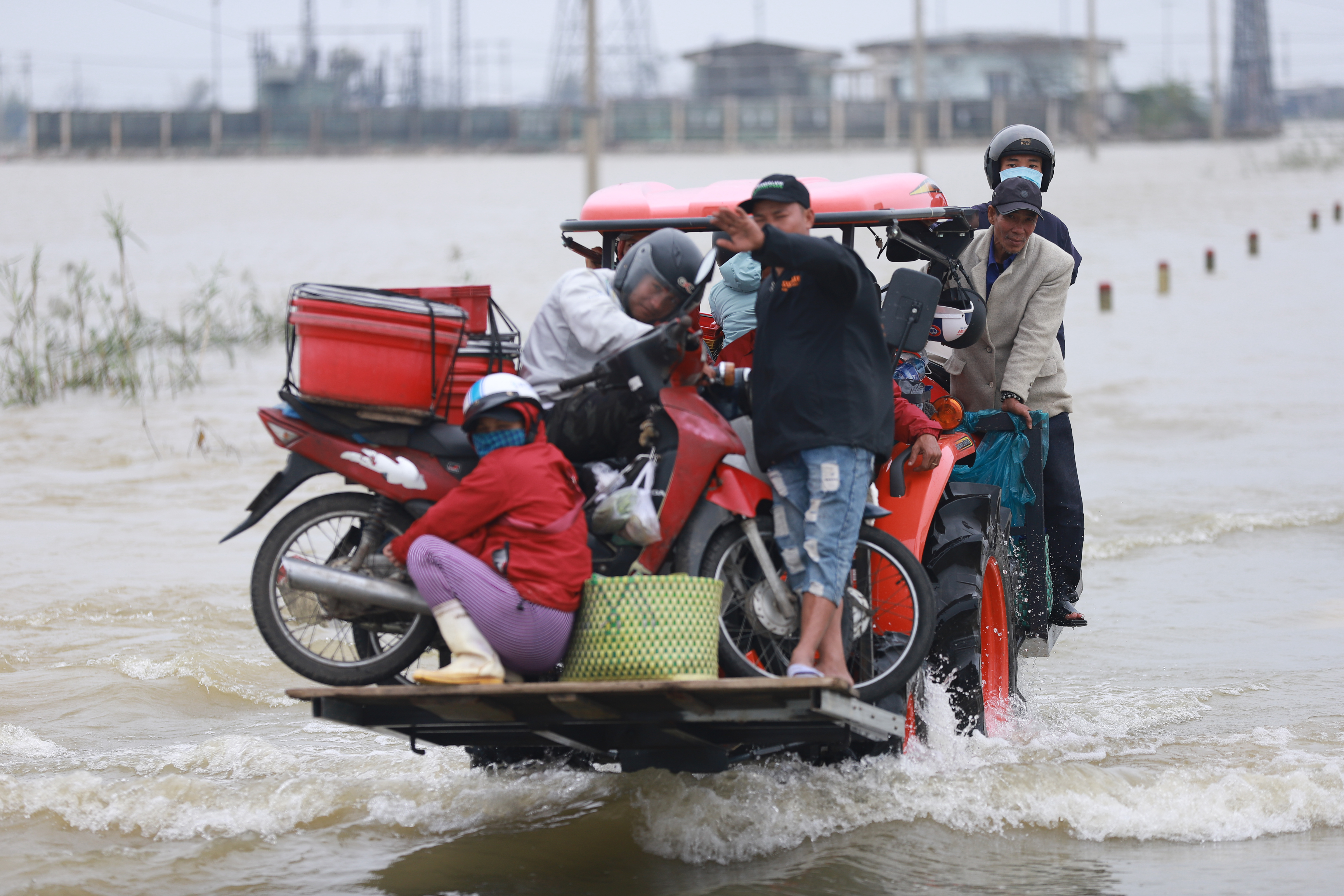 Residents hitch a ride on a forklift truck to dry land through flood waters brought by heavy rain from Typhoon Vamco in Thua Thien Hue province on November 15 [File: Huy Thanh/AFP]