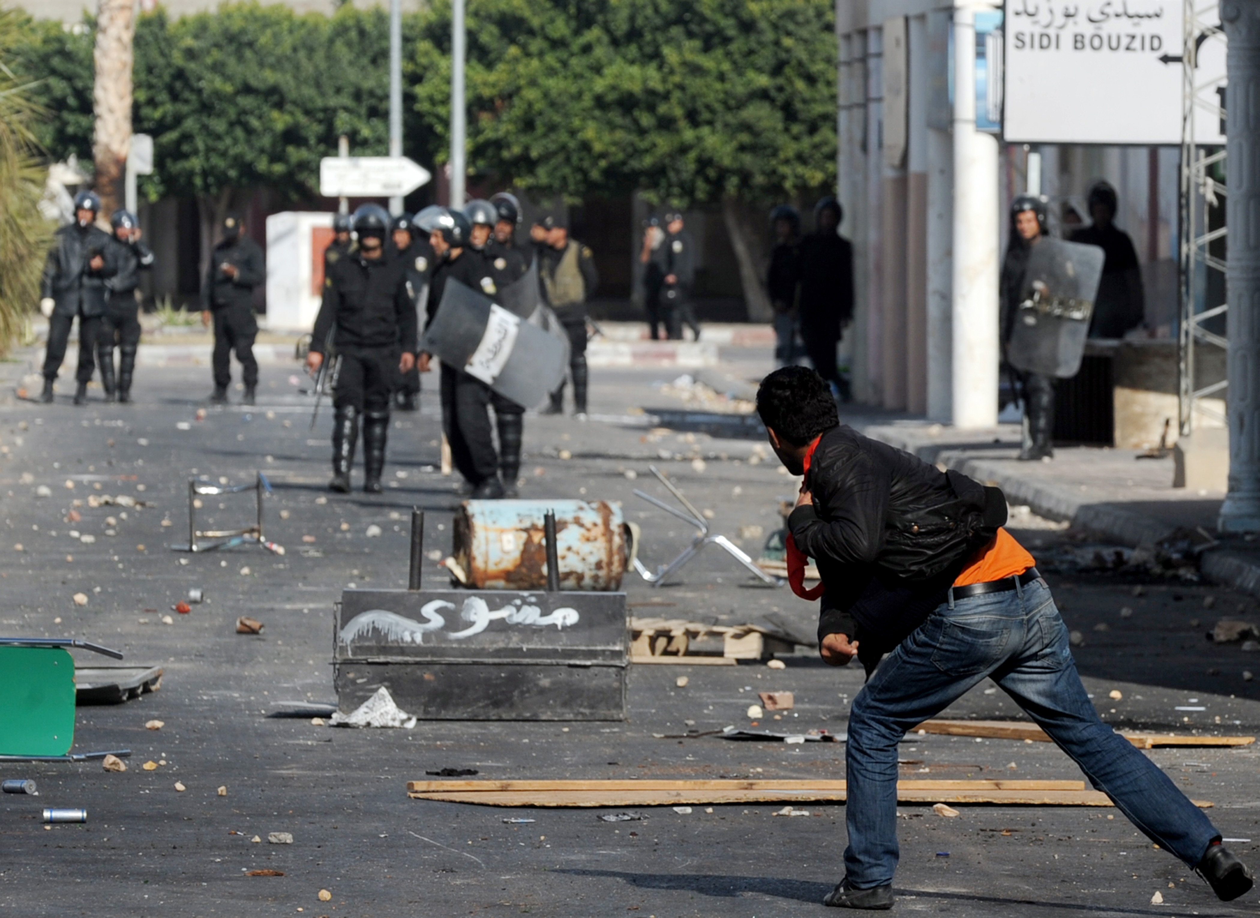 A Tunisian demonstrator throws a rock during clashes with security forces in Regueb, near Sidi Bouzid on January 10, 2011 [Fethi Belaid/AFP]