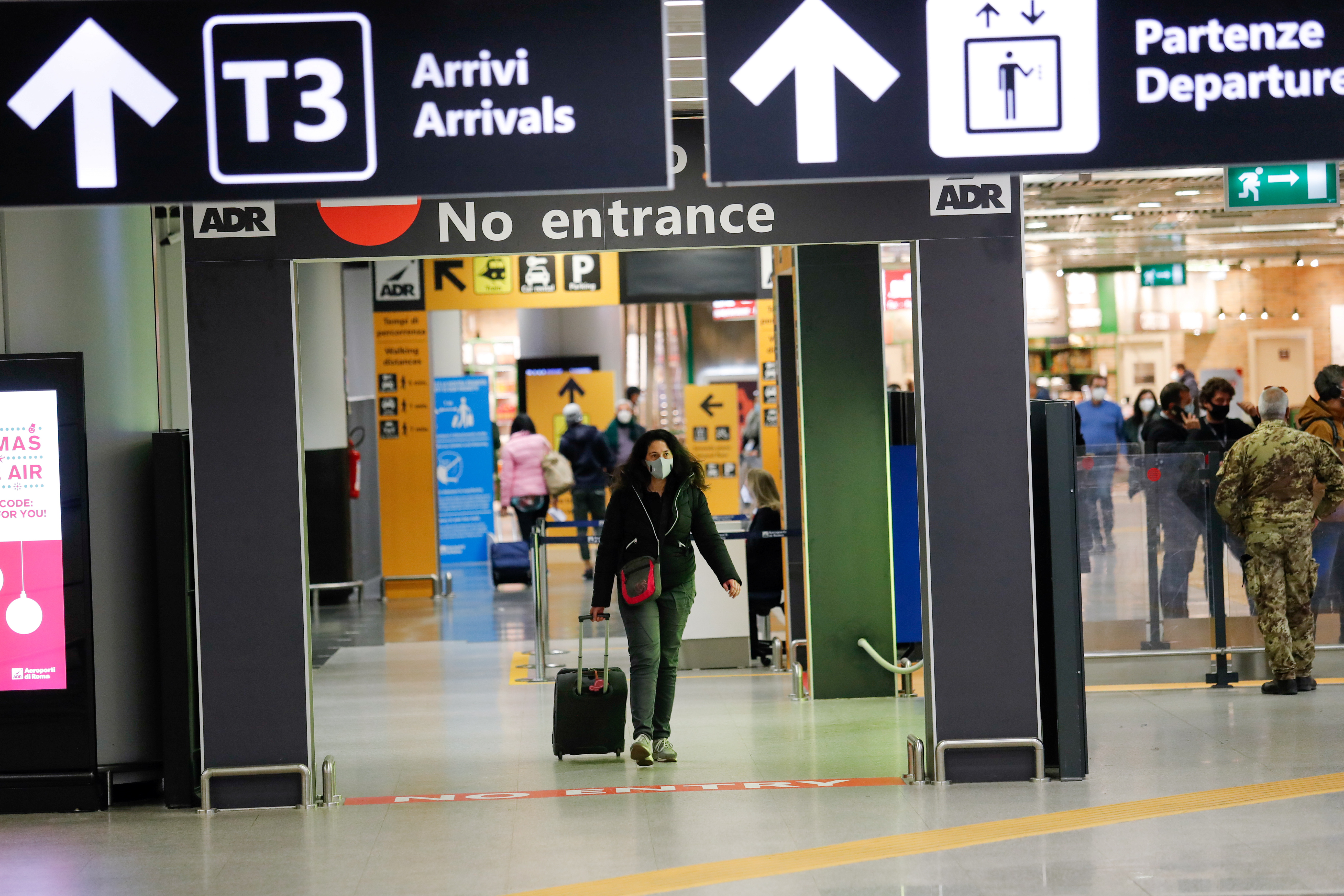 A passenger walks at Rome airport after Italy announced all flights to and from the UK will be suspended [Remo Casilli/Reuters]