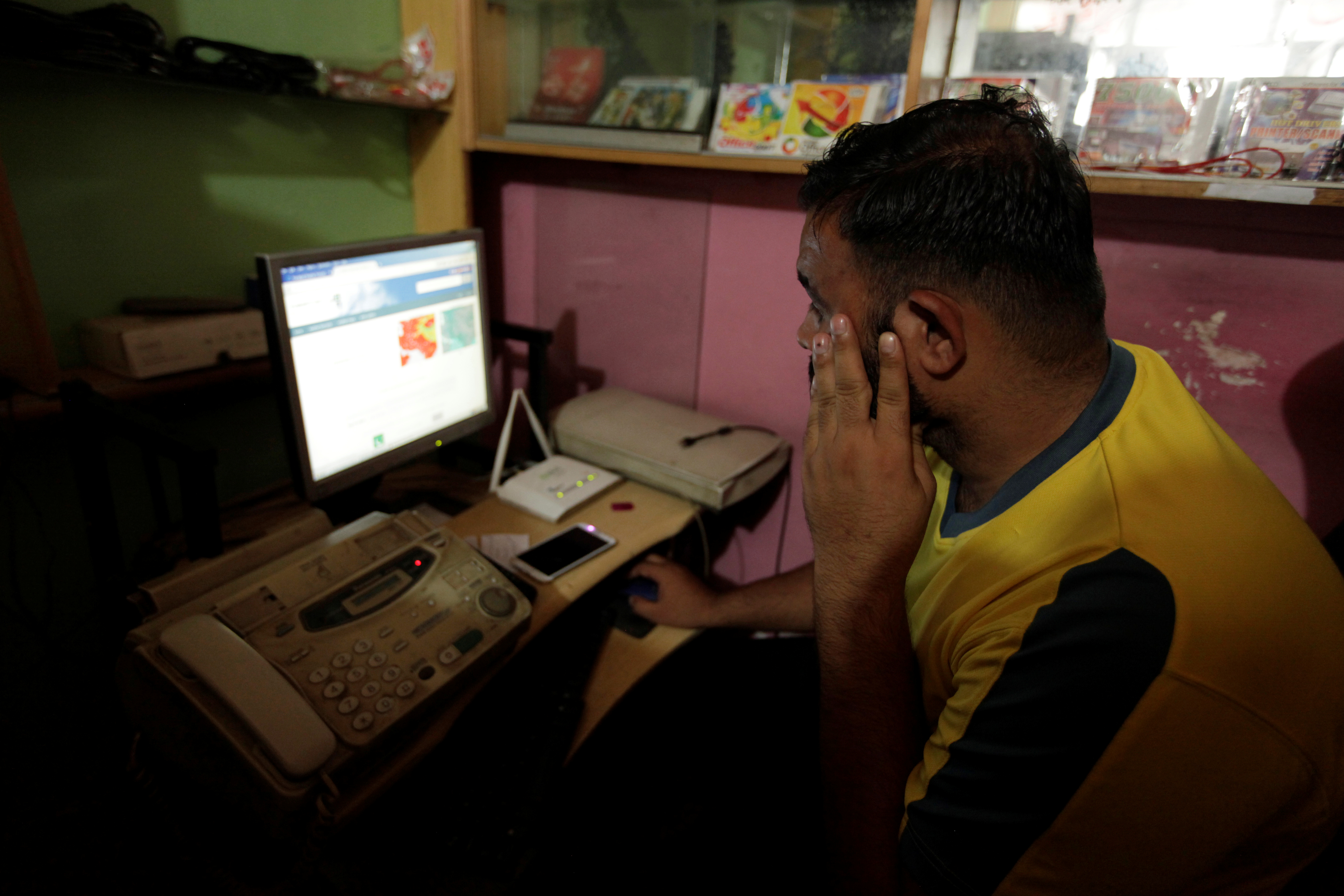 A man explores social media on a computer at an internet cafe in Islamabad [Faisal Mahmood/Reuters]