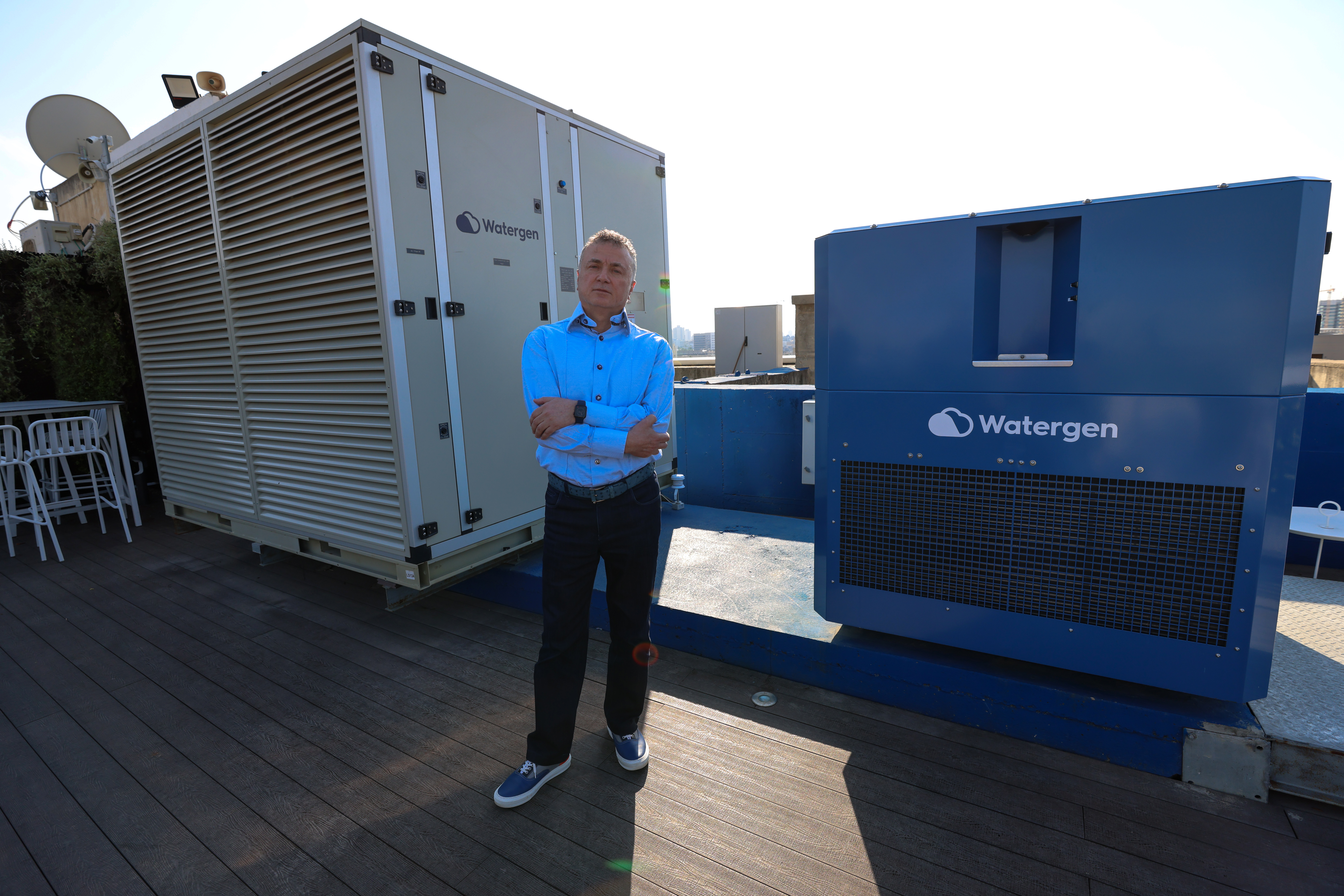 Watergen CEO Michael Mirilashvili stands by one of his company&#39;s machines that transform air humidity into drinkable water [Emmanuel Dunand/AFP]