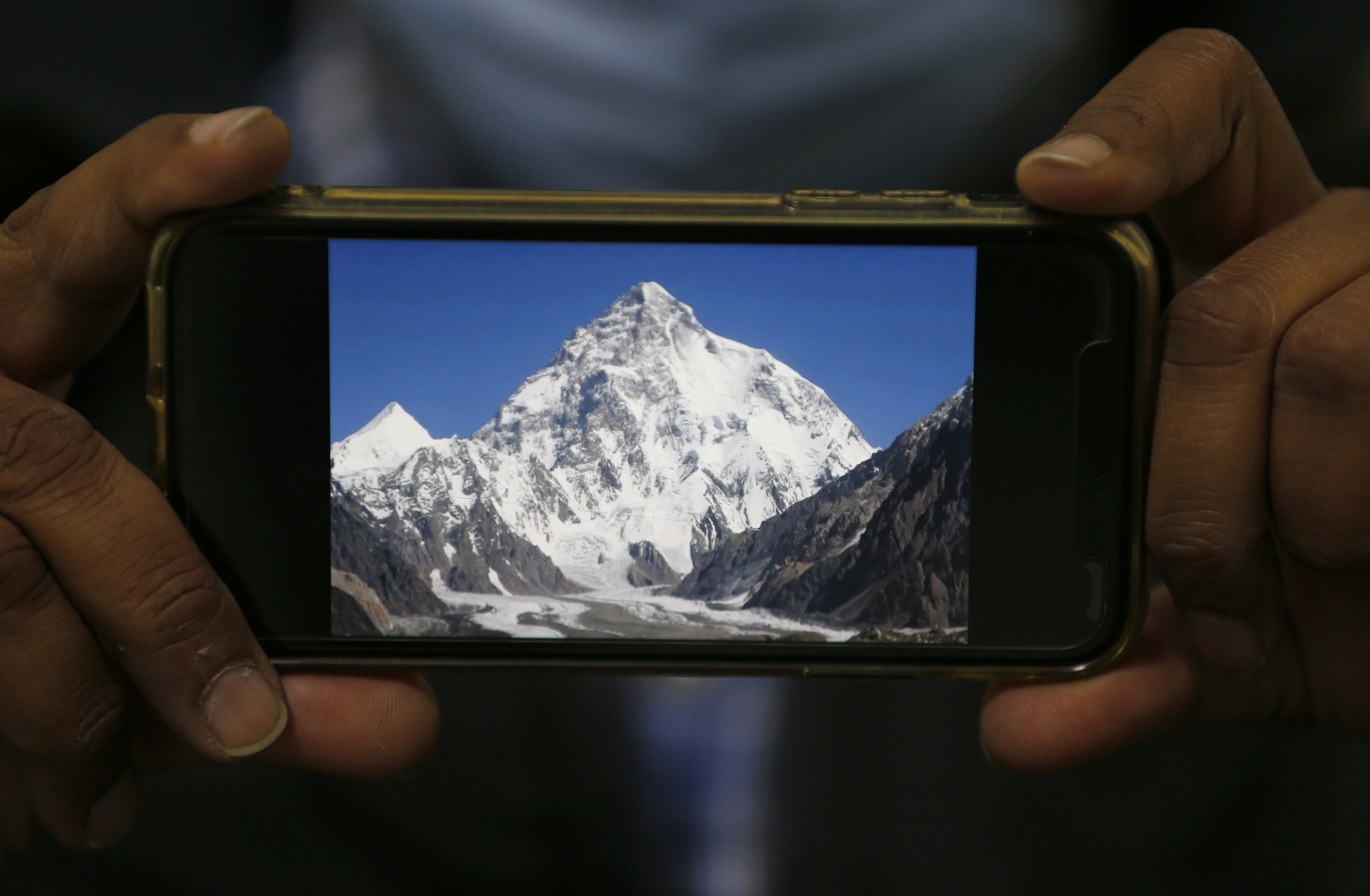 A photo of K2, the world&#39;s second-highest mountain, is displayed on a mobile phone in Islamabad, Pakistan [Anjum Naveed/AP]