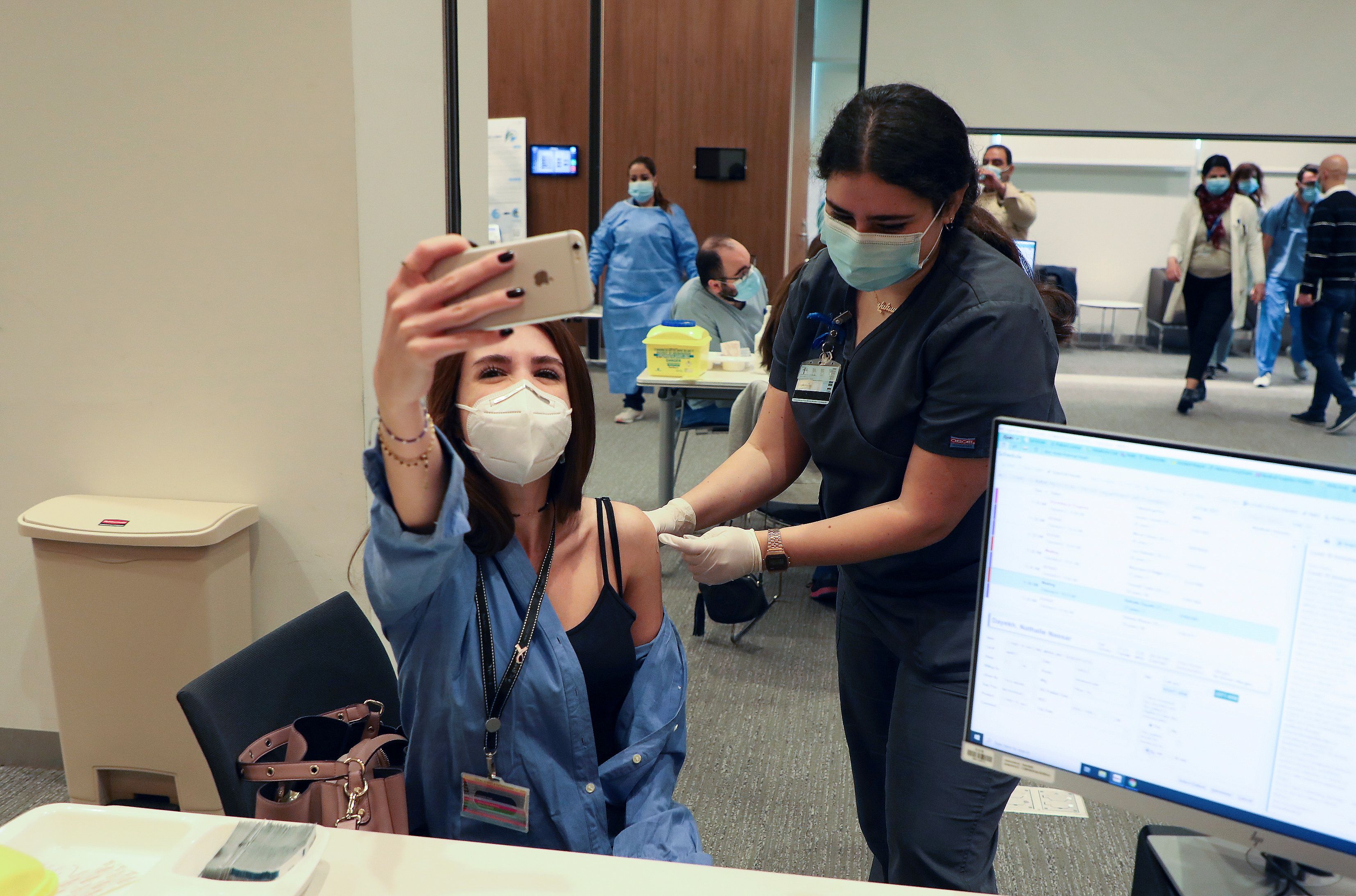 A woman receives the Pfizer-BioNTech vaccine at American University of Beirut&#39;s medical centre on Sunday [Mohamed Azakir/Reuters]