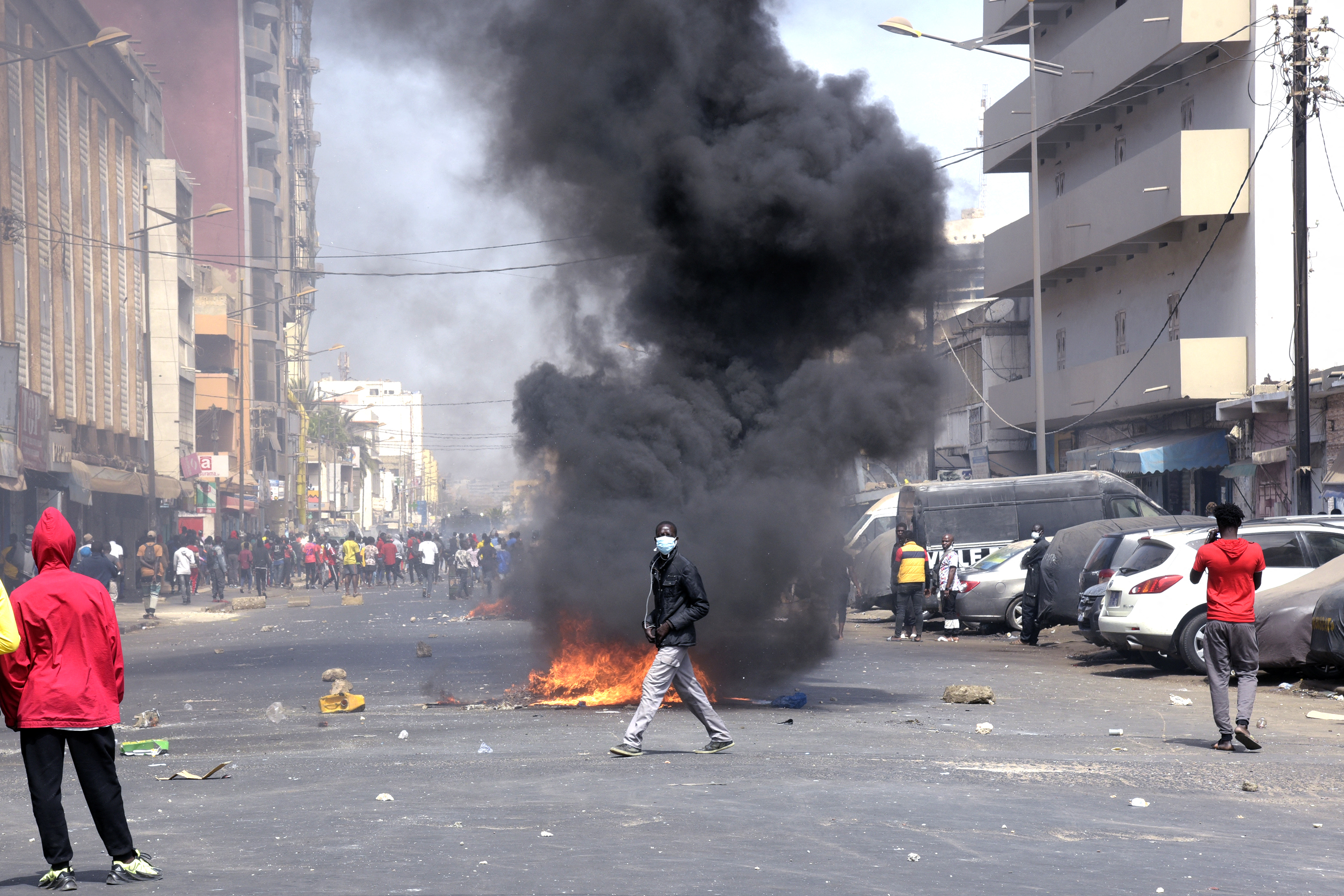 Protesters walk on Blaise Diagne avenue in Dakar during clashes following the arrest of main opposition leader Ousmane Sonko [Seyllou/AFP]