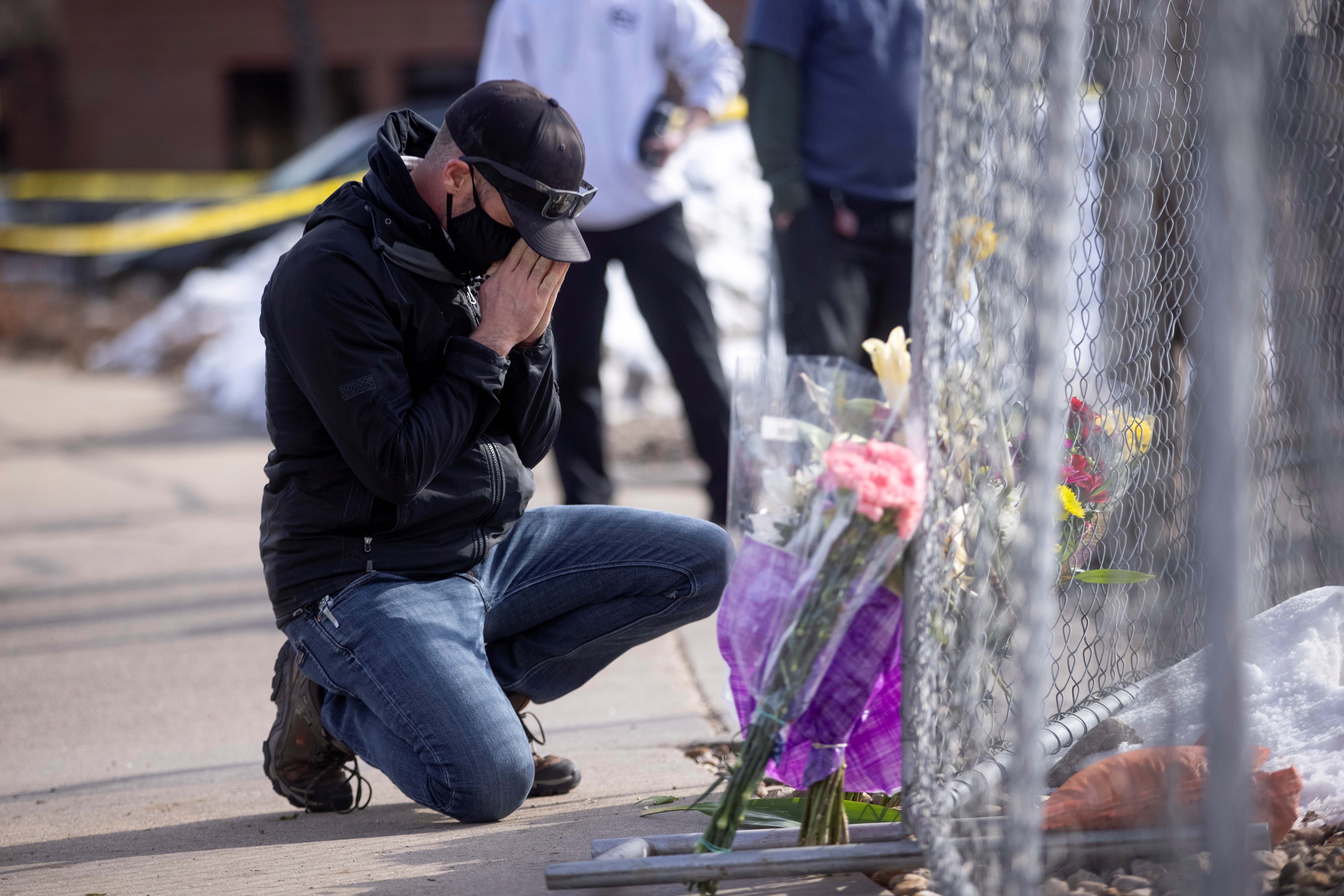 Conrad Wright leaves flowers and takes a moment at the site of a mass shooting at King Soopers grocery store, in Boulder, Colorado, [Alyson McClaran/Reuters]