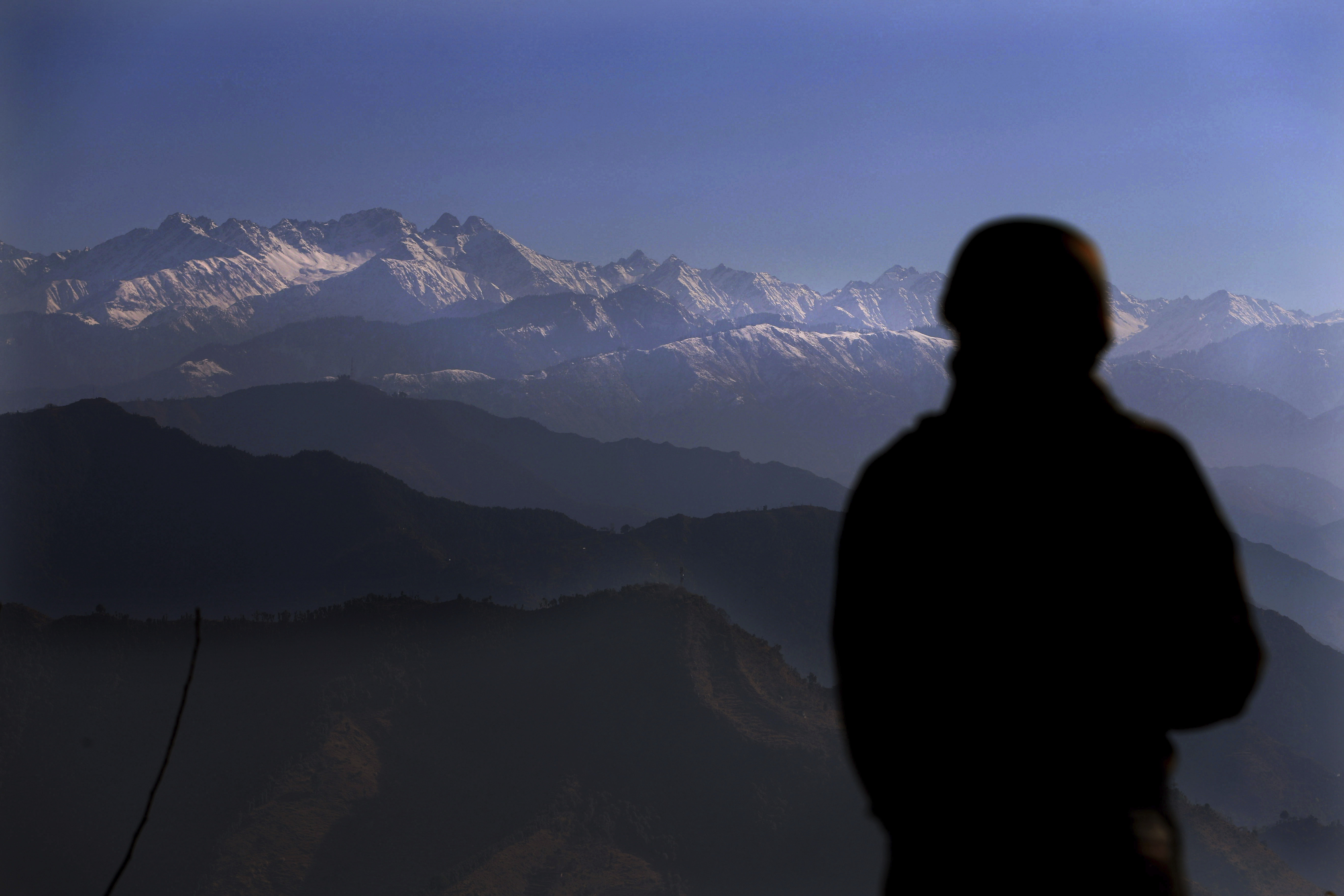 An Indian soldier looks towards the snow-covered Pir Panjal range in the Himalayas from a forward post at LoC between India and Pakistan, in Poonch, Indian-administered Kashmir [File: Channi Anand/AP]