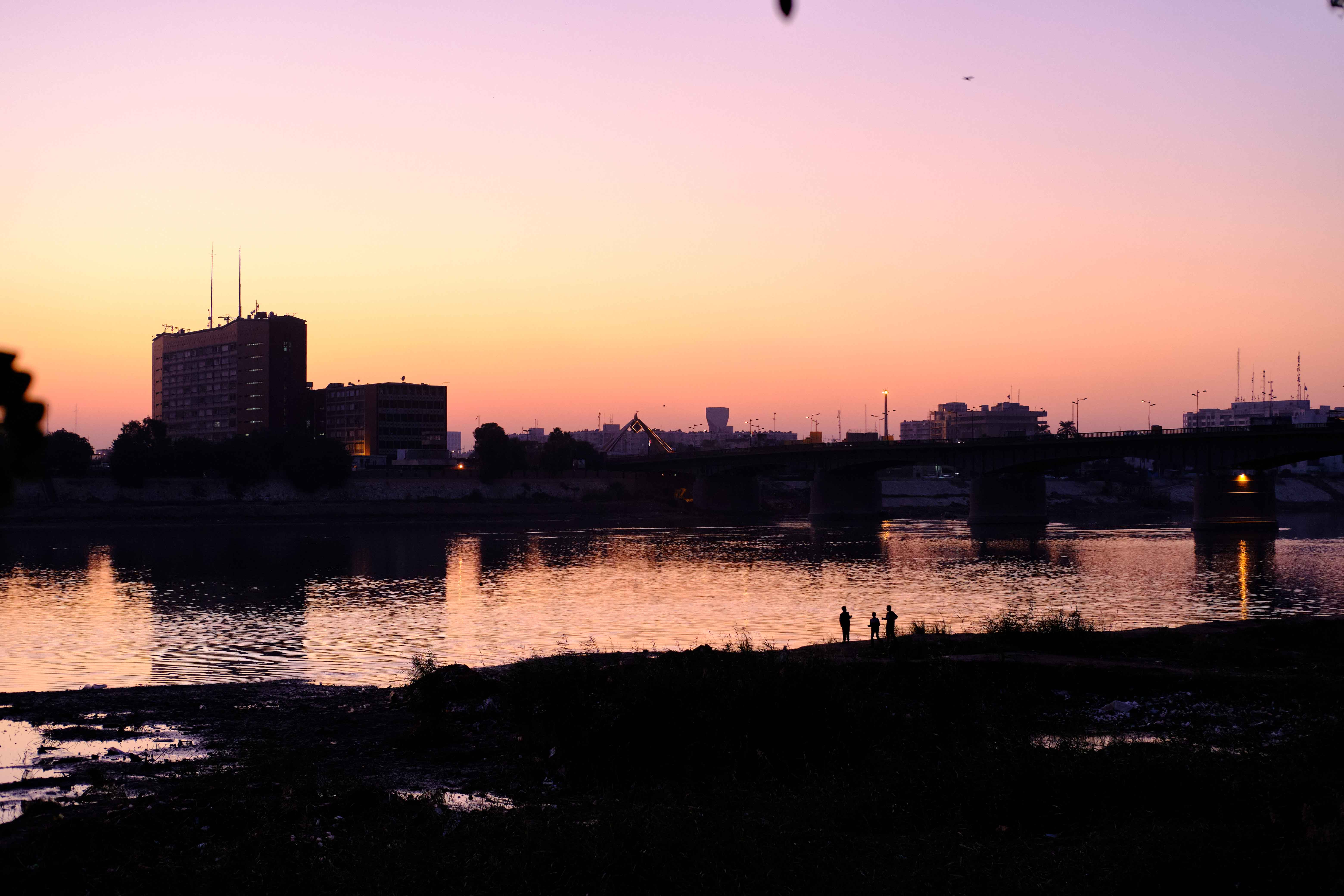 People on the bank of the Tigris river at sunset in Baghdad, Iraq on December 6, 2020 [Nabil Salih/Al Jazeera]