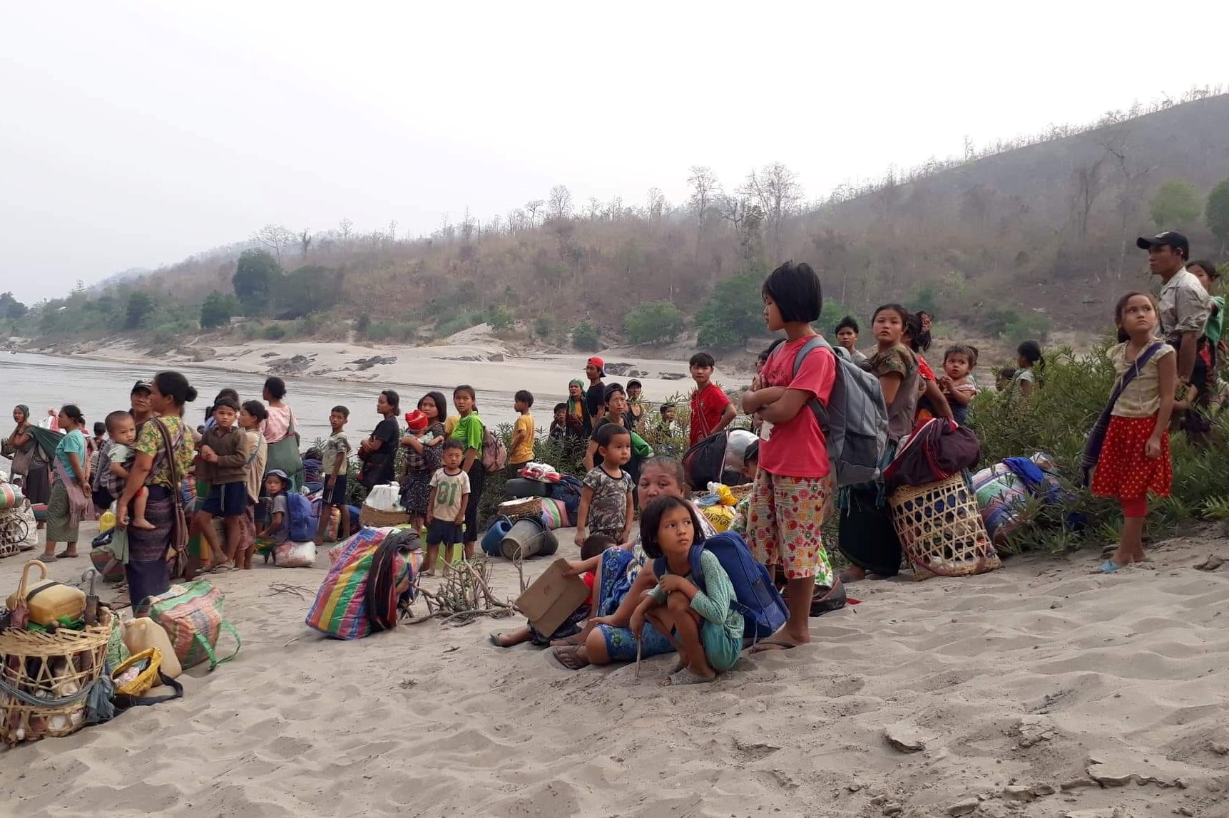 Karen refugees carrying belongings are seen at Salween riverbank in Mae Hong Son, Thailand on March 29, 2021 [Karen Women&#39;s Organization/Handout via Reuters]