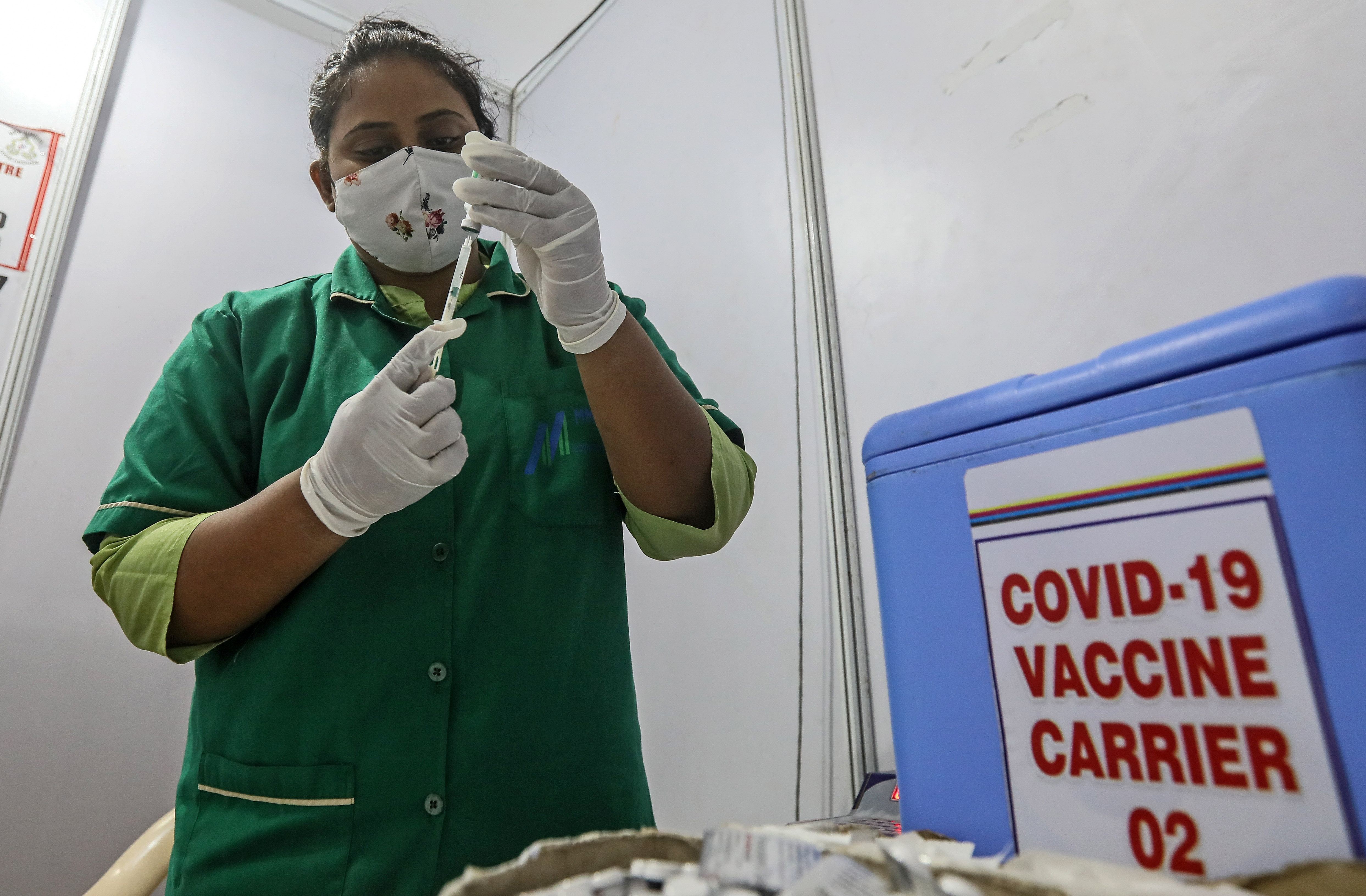 A nurse prepares a shot of COVID-19 vaccine inside a vaccination centre in Mumbai [File: Divyakanat Solanki/EPA]