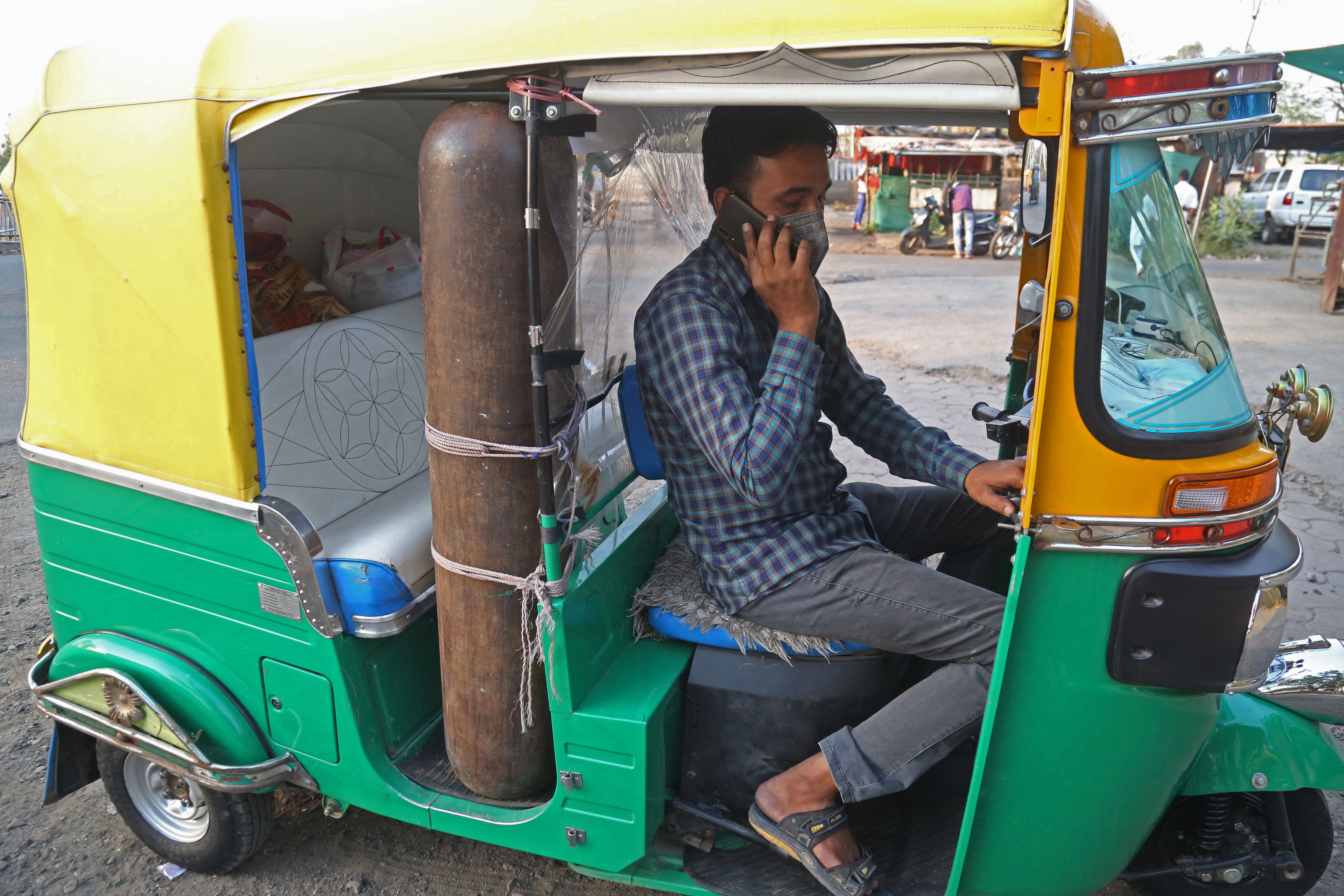 Khan in his auto-rickshaw that he converted into an ambulance by fitting an oxygen cylinder with accessories to serve COVID-19 patients for free in Bhopal [Gagan Nayar/AFP]