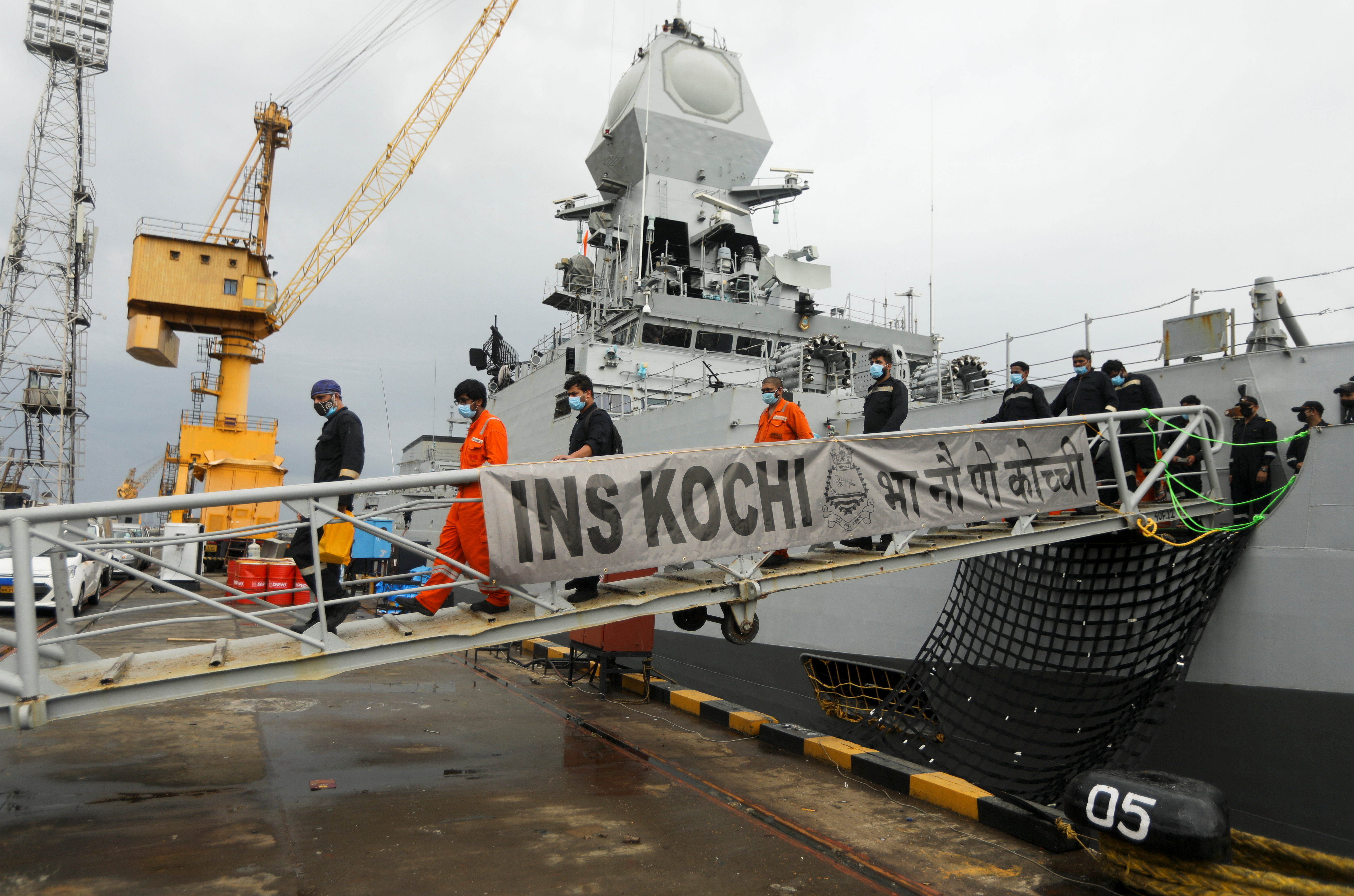 People stranded at sea on board a barge due to Cyclone Tauktae exit Indian naval ship INS Kochi after they were rescued, in Mumbai [Francis Mascarenhas/Reuters]