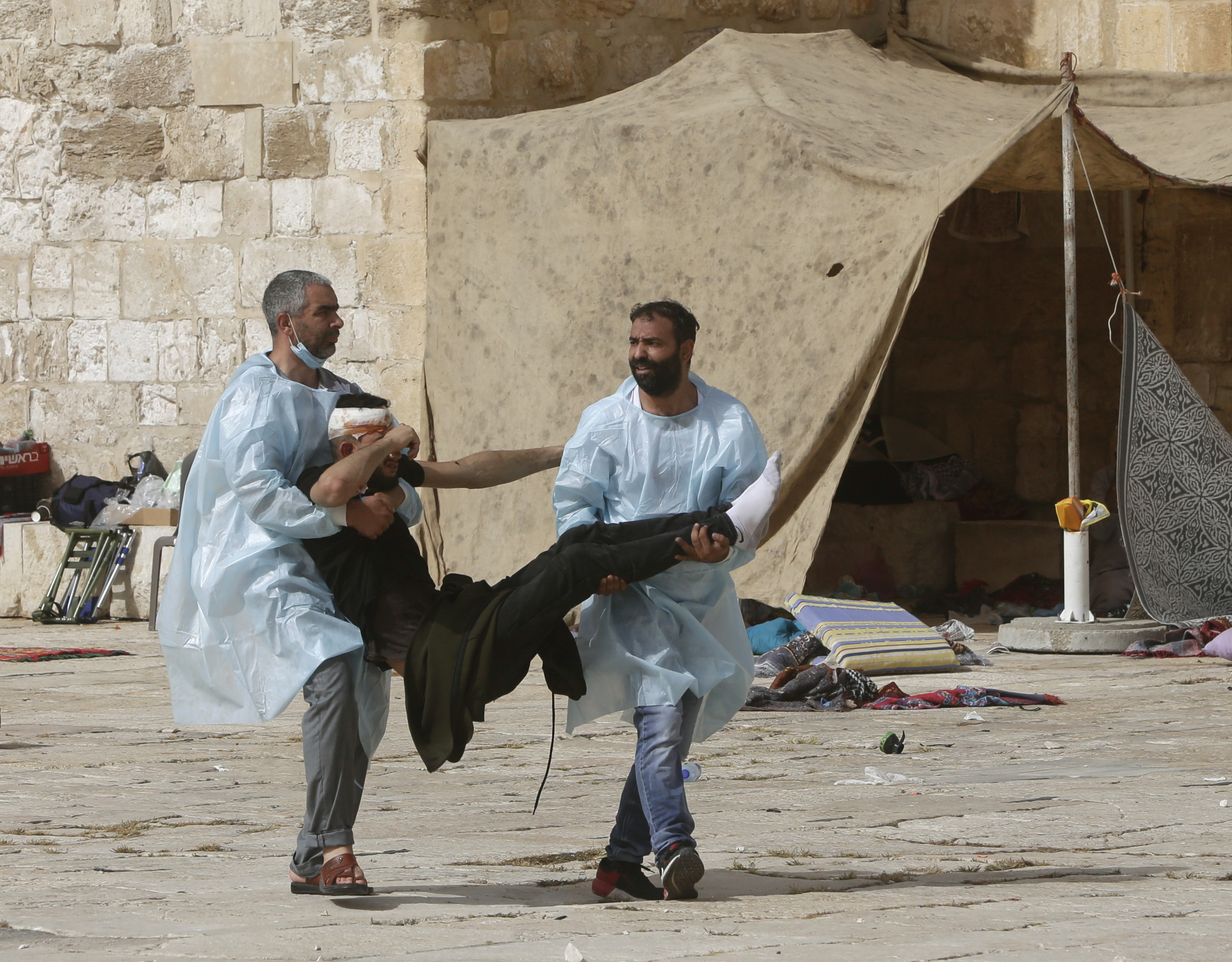 Palestinians evacuate a wounded man after Israeli security forces stormed the Al-Aqsa Mosque compound on Monday [Mahmoud Illean/AP]