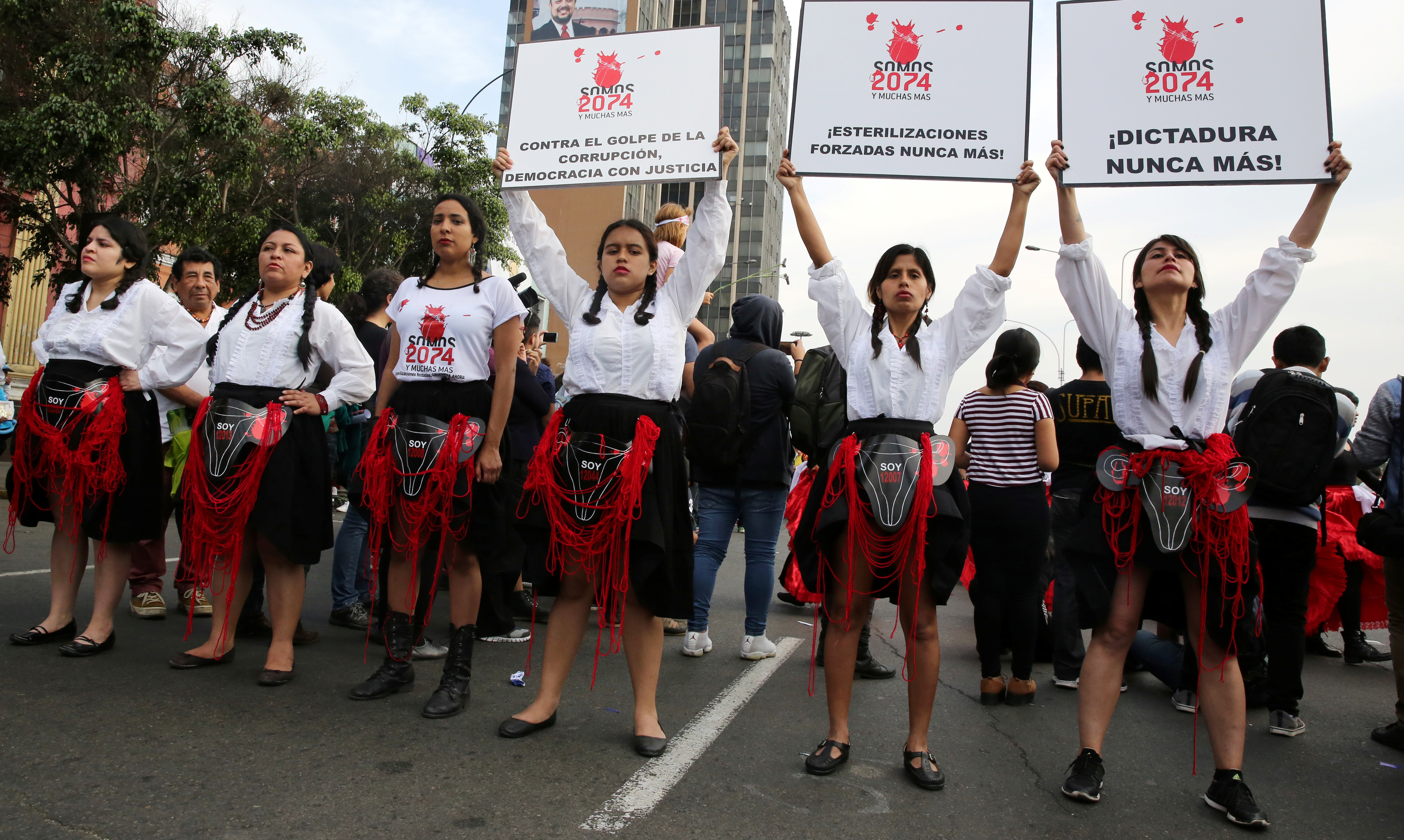 Women hold signs reading &#39;We are 2,074 and more, forced sterilisations never again&#39; during a protest against violence against women in Lima, Peru, in 2017 [File: Mariana Bazo/Reuters]