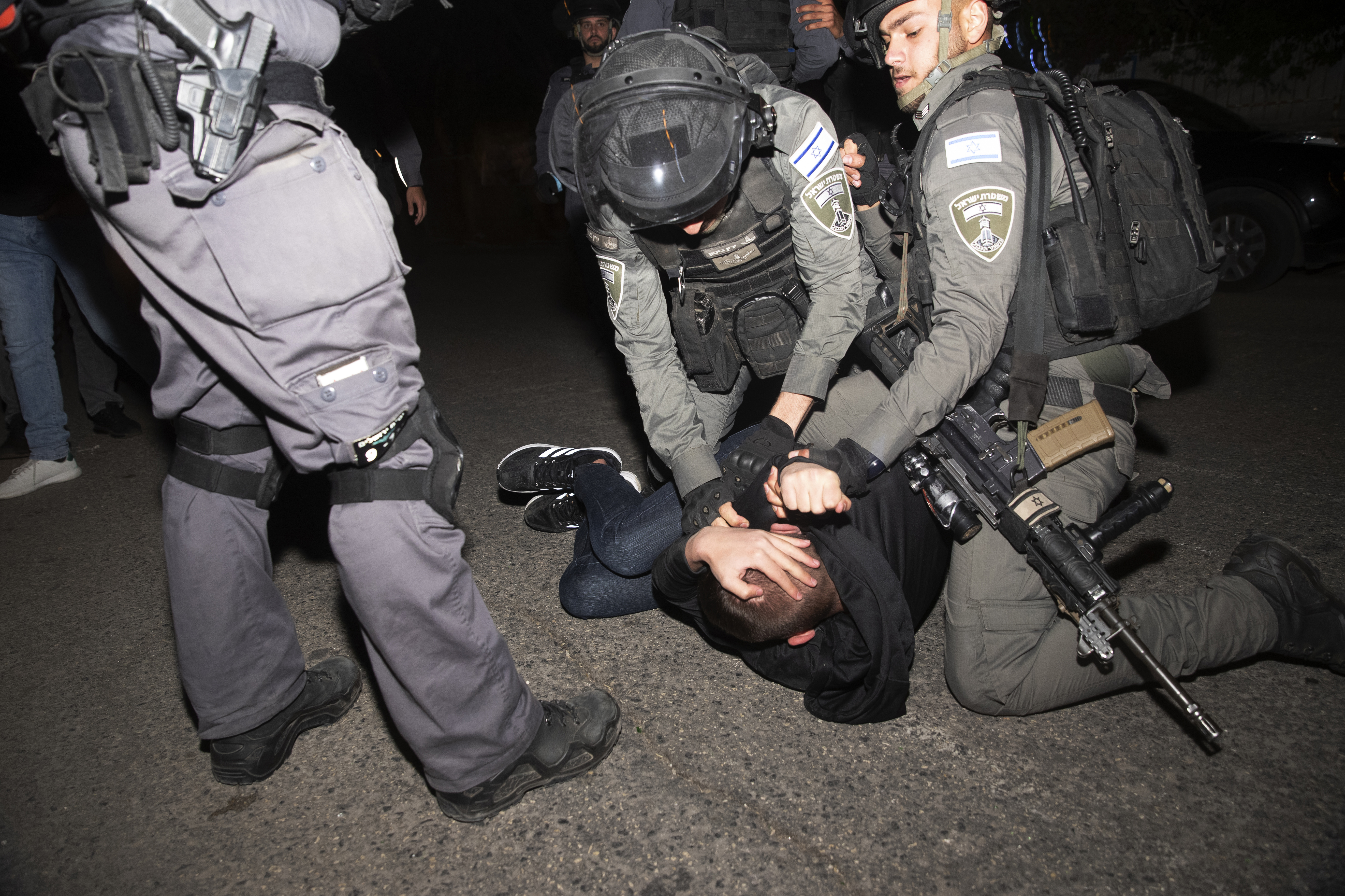 A Palestinian youth is pinned down by Israeli police at a protest against the forcible eviction of Palestinian families [Maya Alleruzzo/AP]
