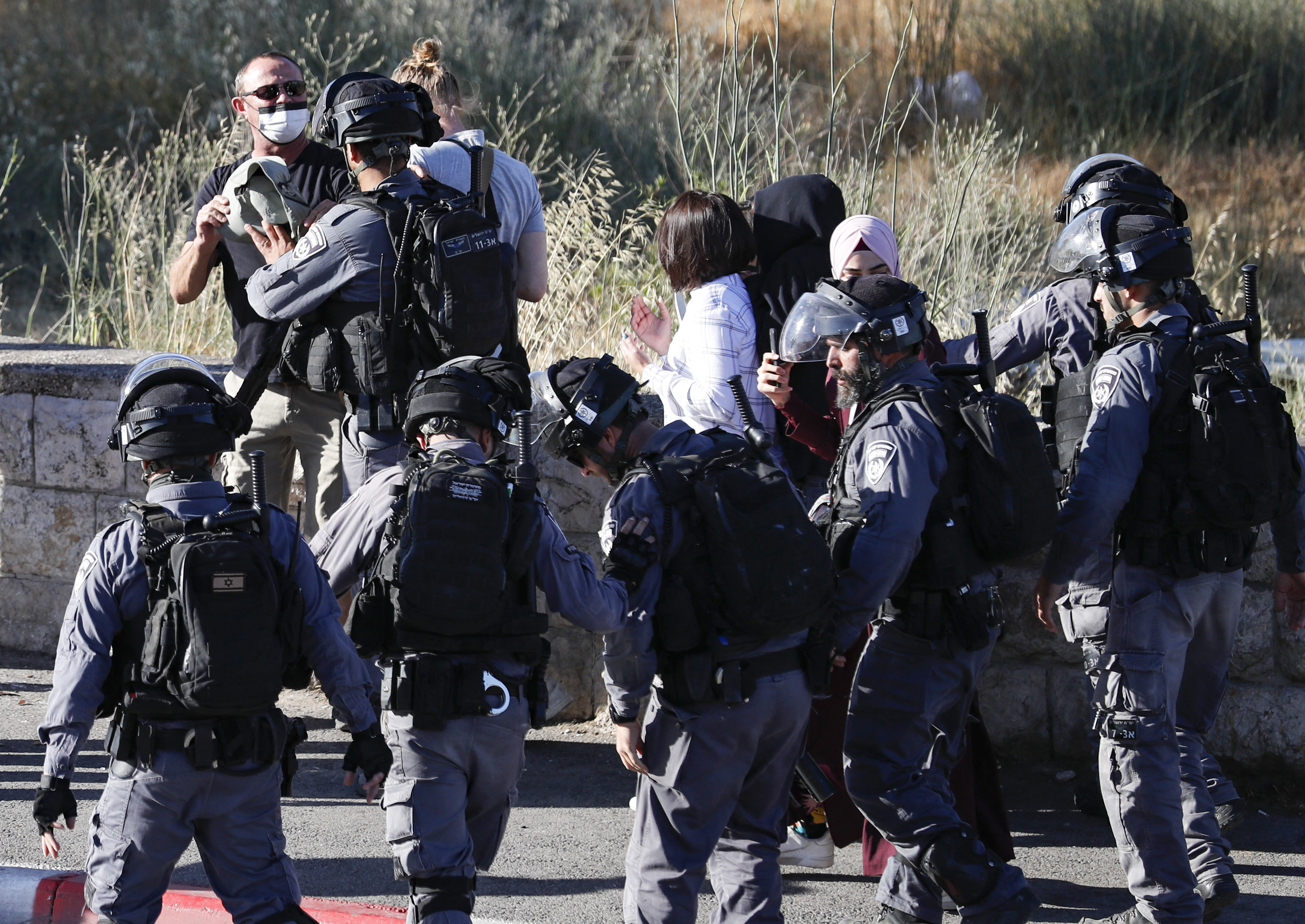 Israel security forces push away Palestinian activists.