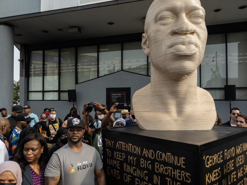 Terrence Floyd (2nd L) stands with attendees at the unveiling of a statue of his brother George [File: Ed Jones/AFP]