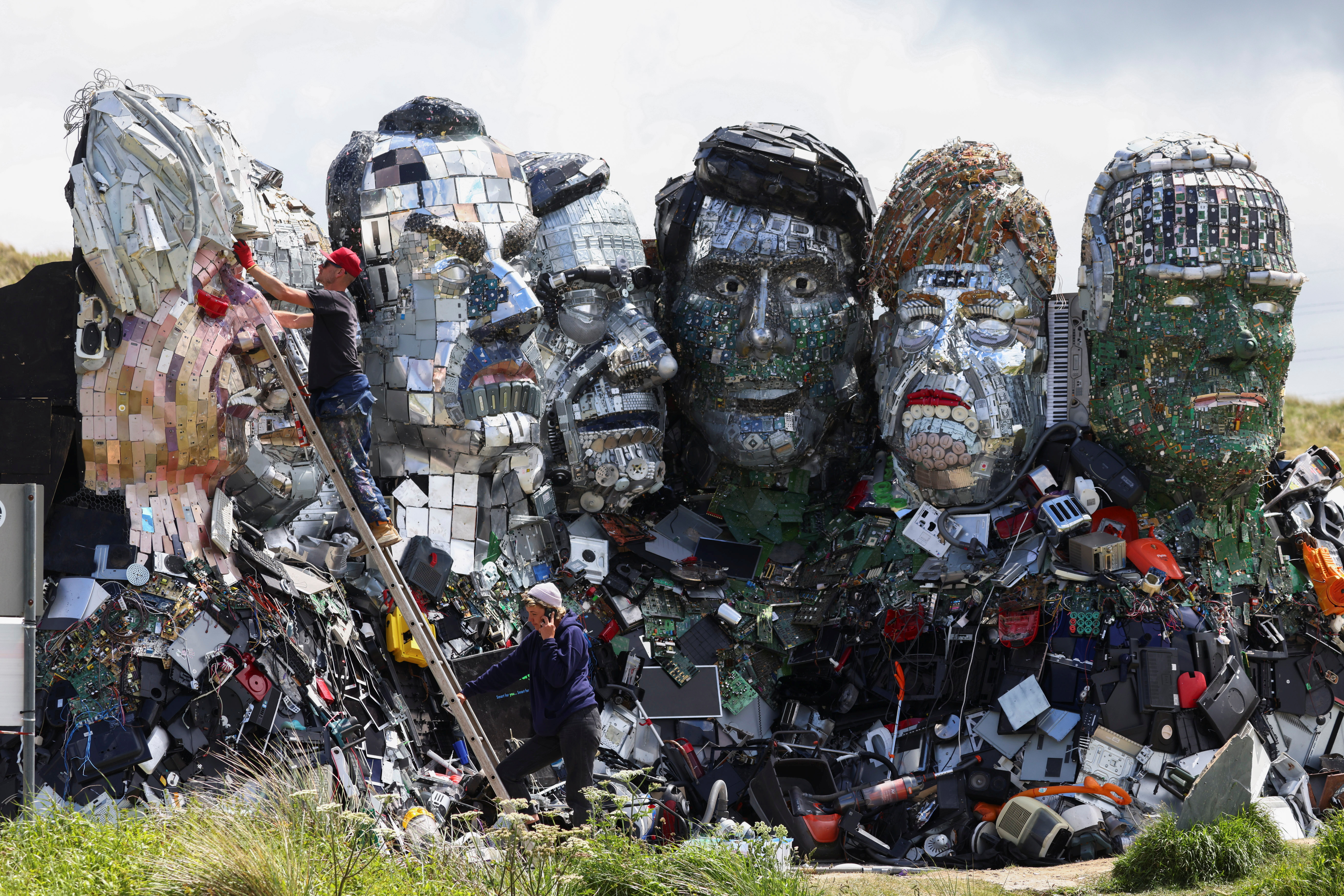 &#39;Mount Recyclemore&#39; is an artwork depicting the G7 leaders looking towards Carbis Bay in Cornwall, where western leaders are meeting to discuss myriad challenges, from fending off autocratic governments and global warming to the lingering coronavirus pandemic and unbalanced trade relations [File: Tom Nicholson/Reuters]