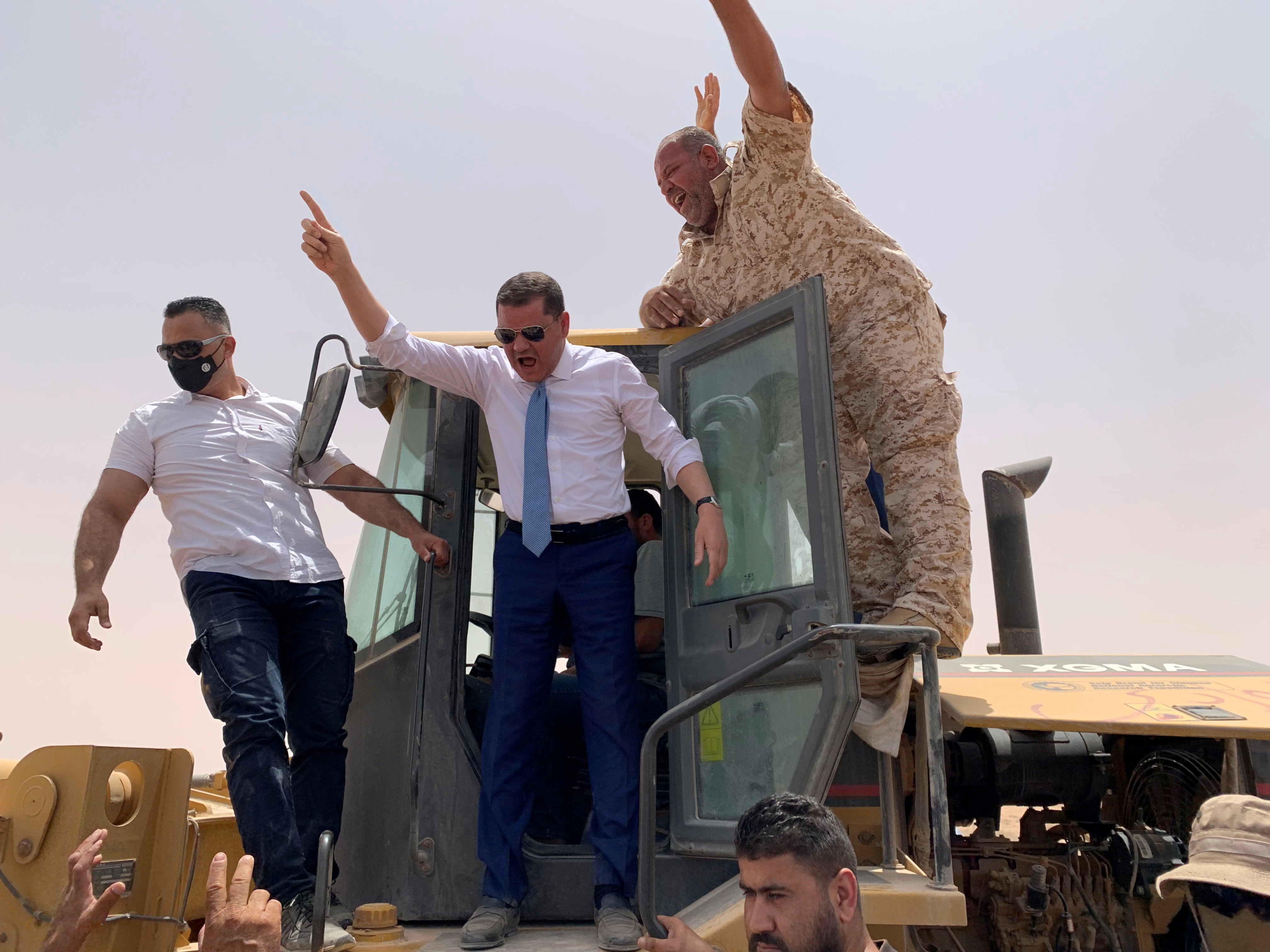 Libyan Prime Minister Abdulhamid Dbeibeh gestures during the re-opening of the cross road across the frozen frontline between east and west in Libya, June 20, 2021. [Ayman al-Sahili/Reuters]
