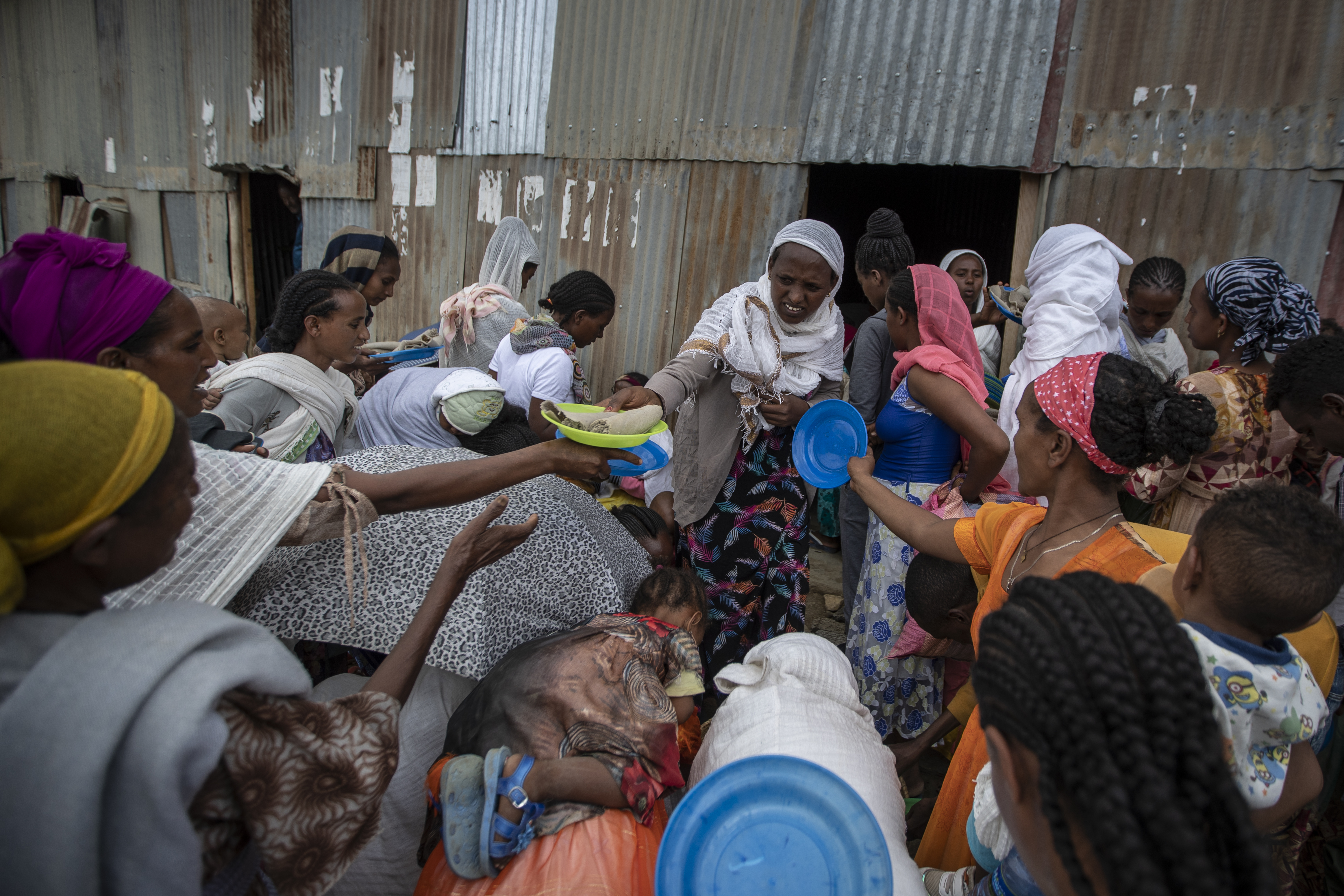 Displaced Tigrayans queue to receive food donated by local residents at a reception center for the internally displaced in Mekele, in the Tigray region of northern Ethiopia [Ben Curtis/AP Photo]