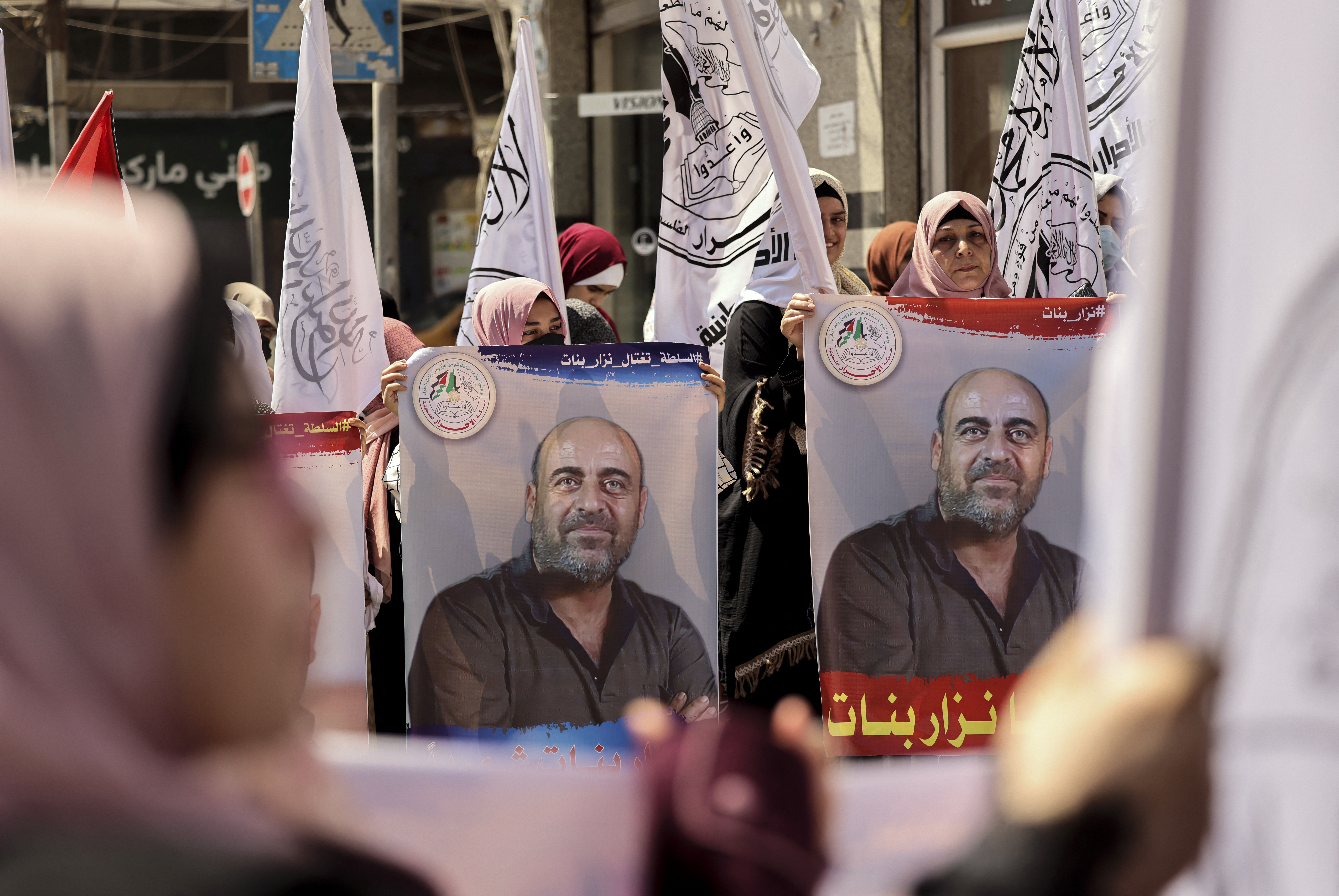 Palestinians hold up posters of human rights activist Nizar Banat during a demonstration in Gaza City [Mohammed Abed/AFP]