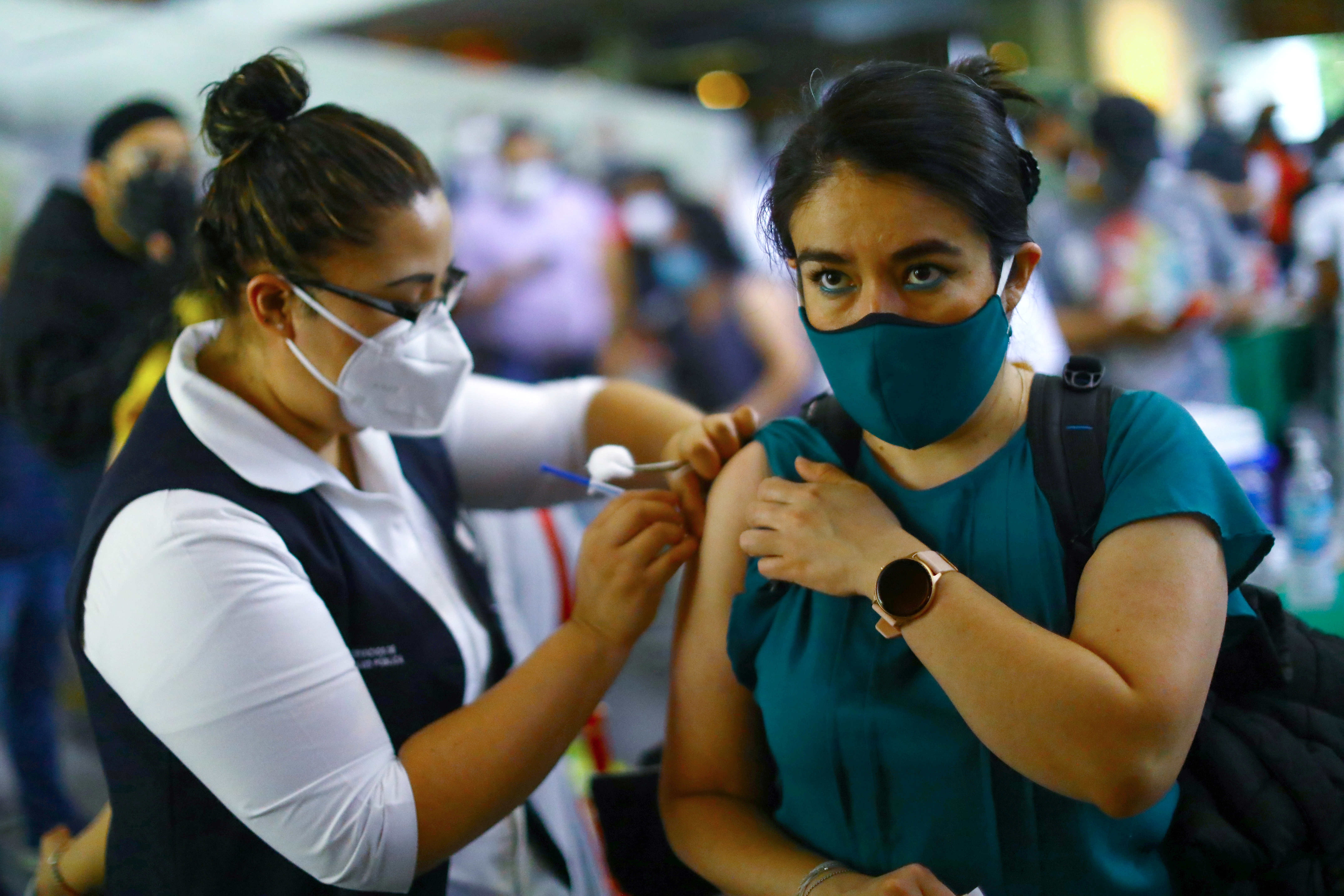 A woman receives a dose of the AstraZeneca COVID-19 vaccine during a mass vaccination in Mexico City [File: Edgard Garrido/Reuters]