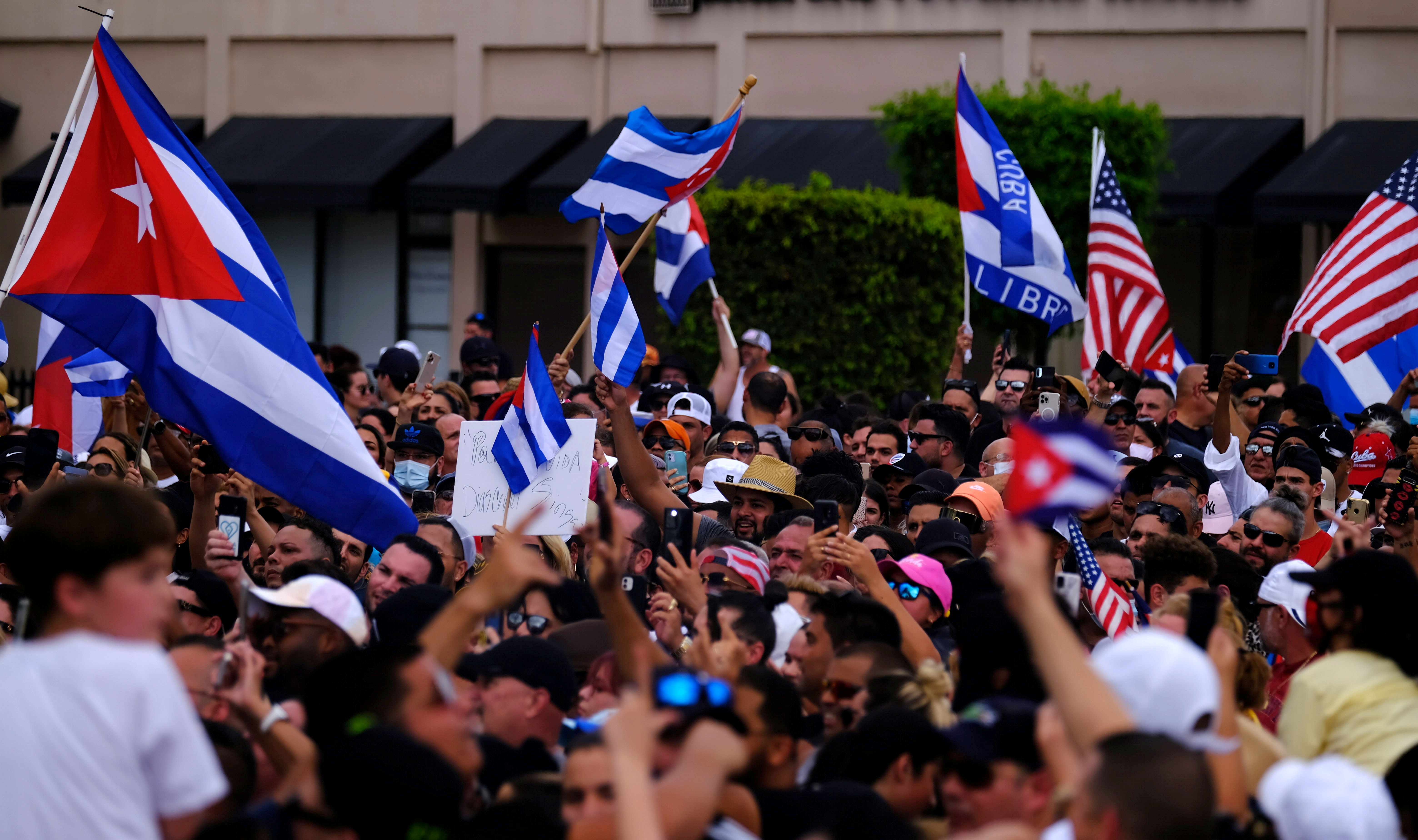 Emigres in Little Havana wave American and Cuban flags as they react to reports of protests in Cuba against the deteriorating economy, in Miami, Florida, July 11, 2021. [Maria Alejandra Cardona/Reuters]