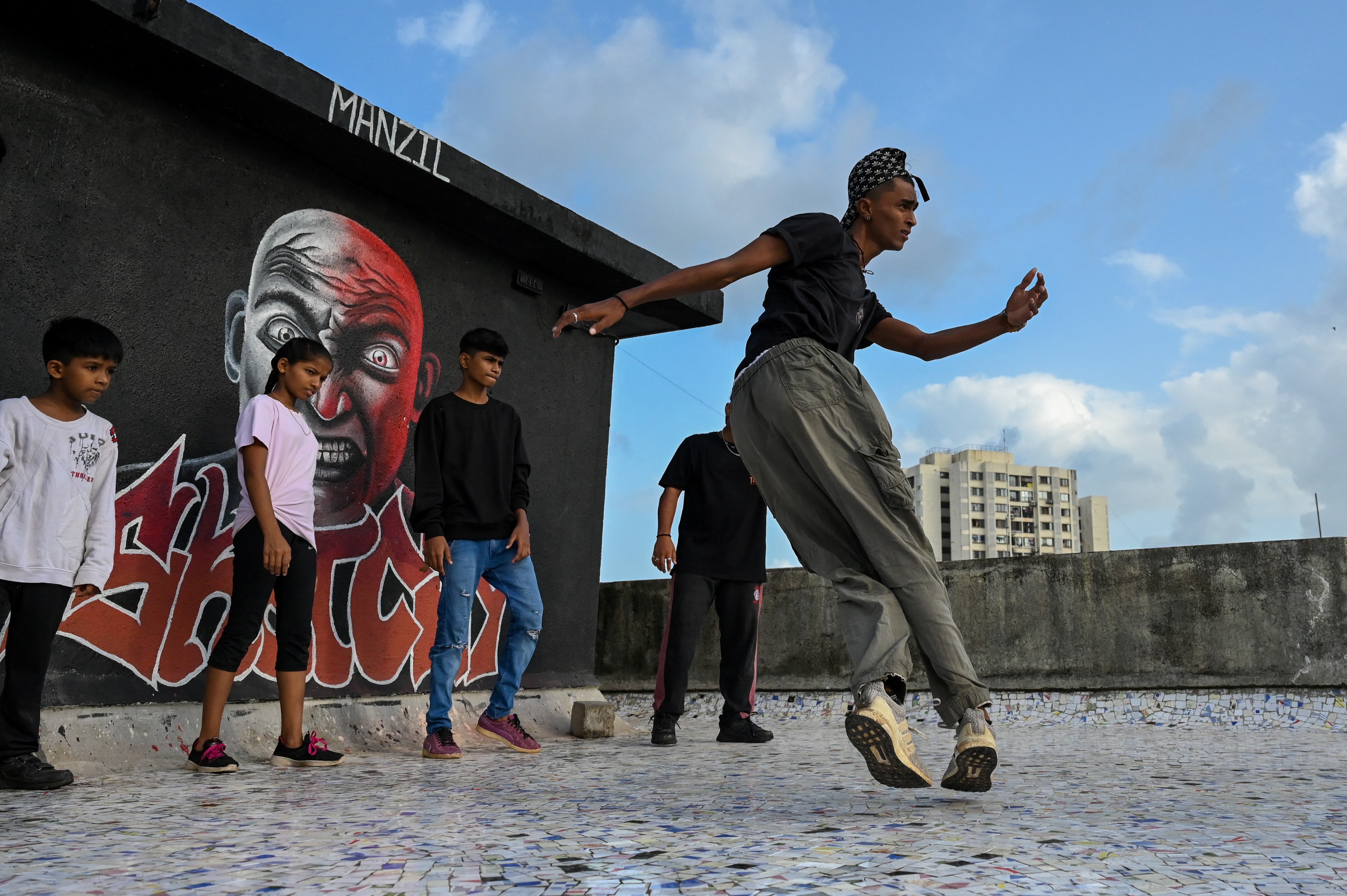 A student performs during a group class to learn breaking or &#34;b-boying&#34; at a training session on the rooftop of a building in Dharavi slums, Mumbai. [Ammu Kannampilly/AFP]